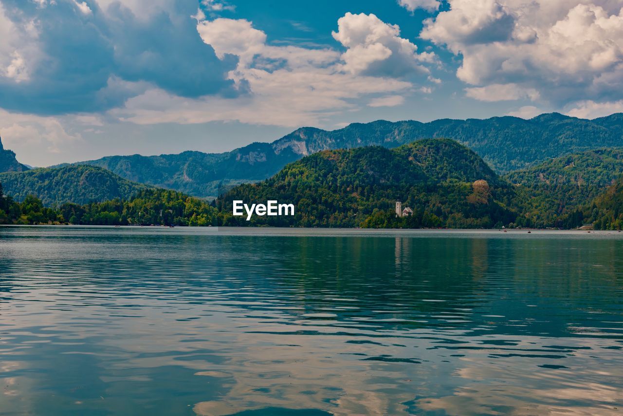 Scenic view of lake by mountains against sky