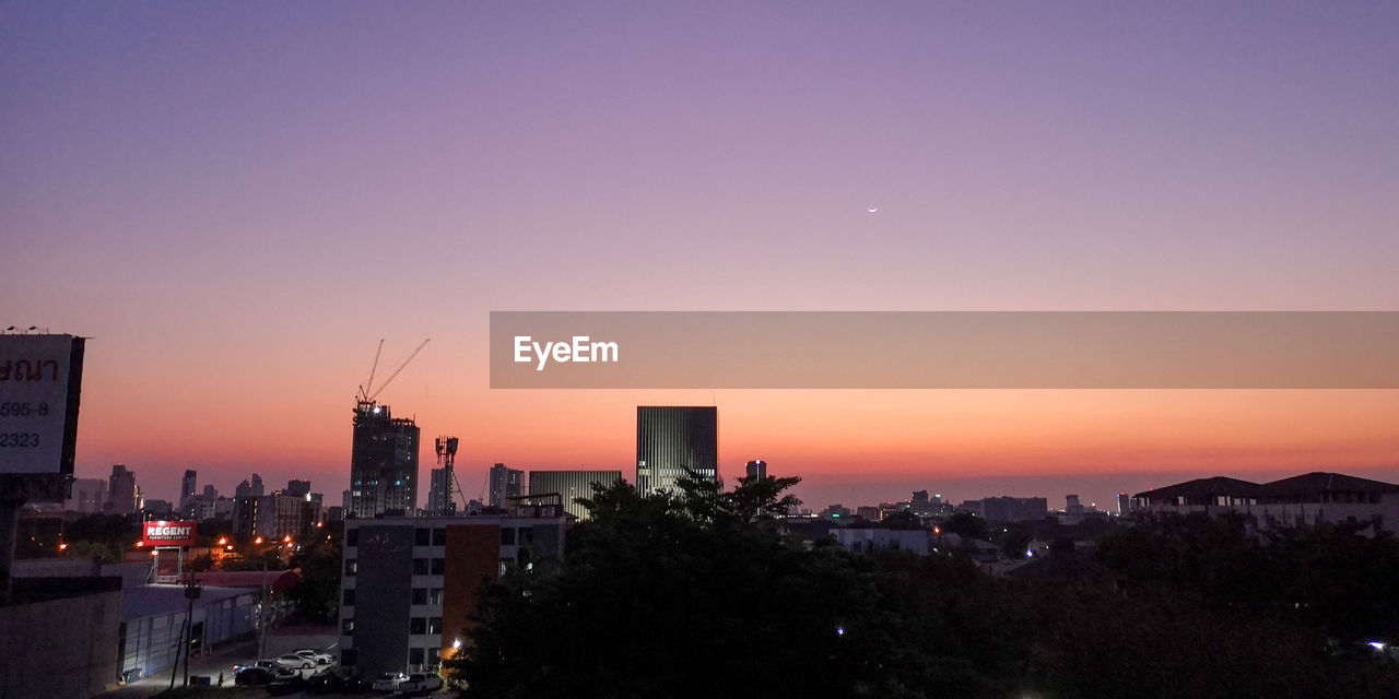 CITY BUILDINGS AGAINST CLEAR SKY DURING SUNSET