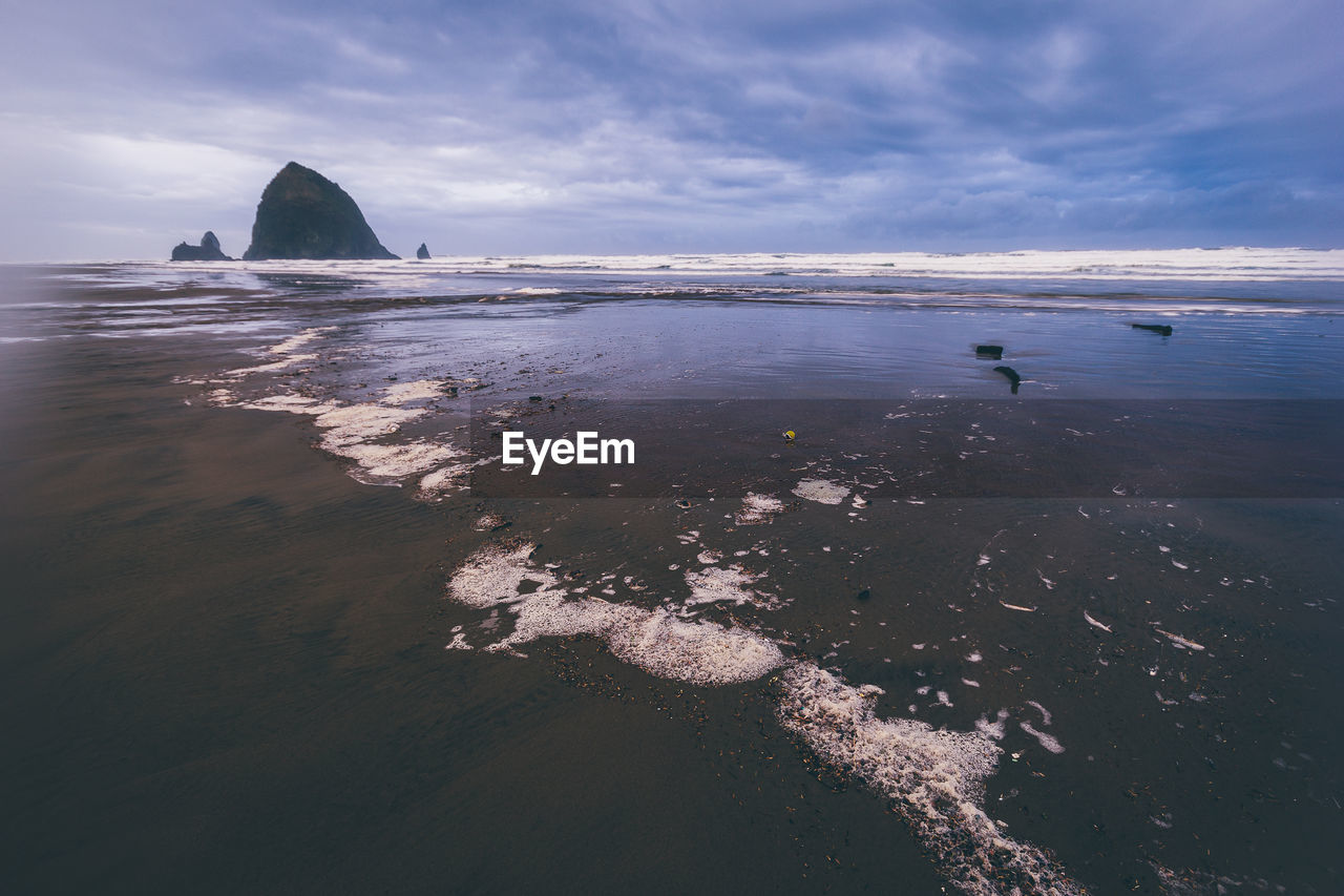 View of beach against cloudy sky