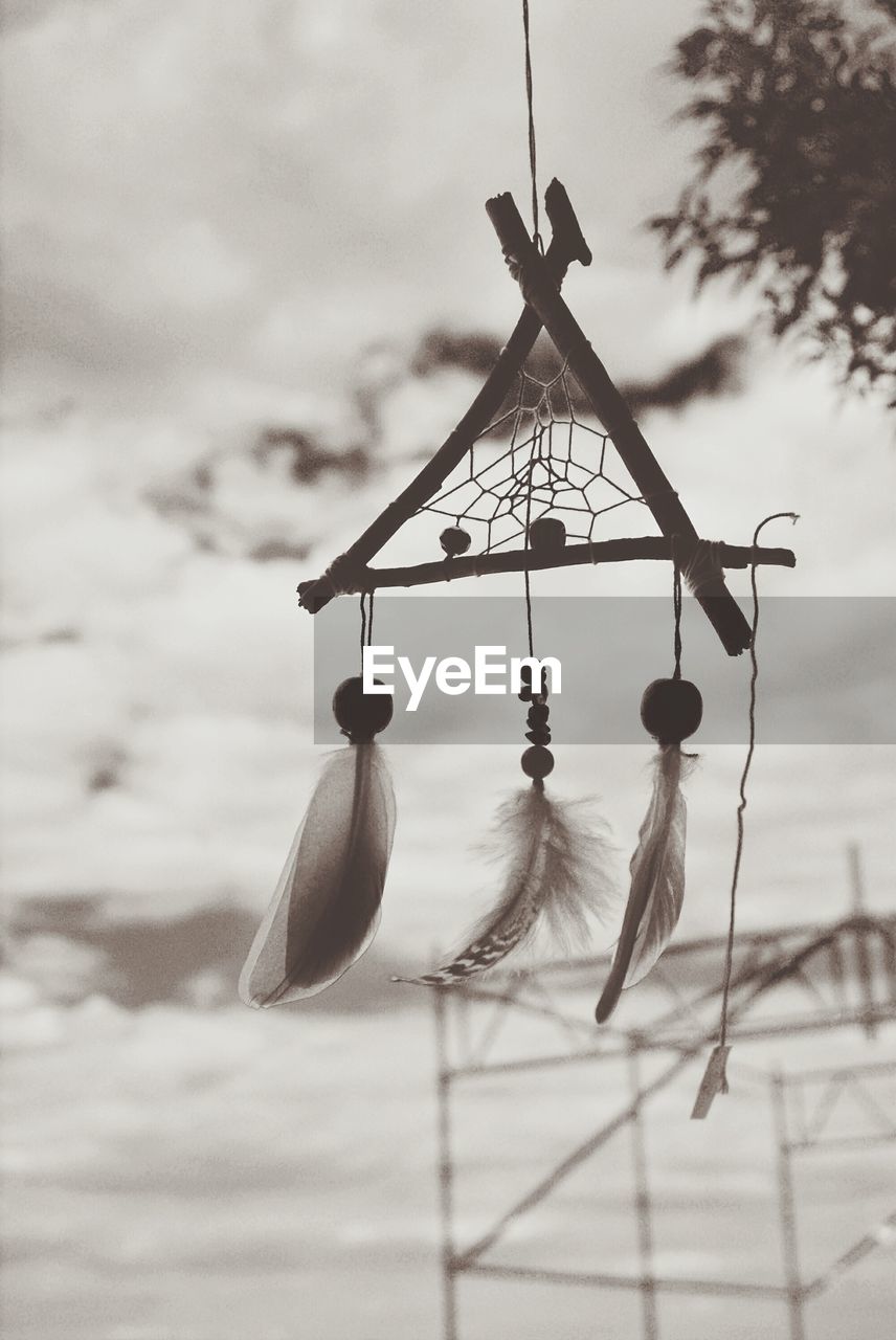 Close-up of wind chimes against the sky