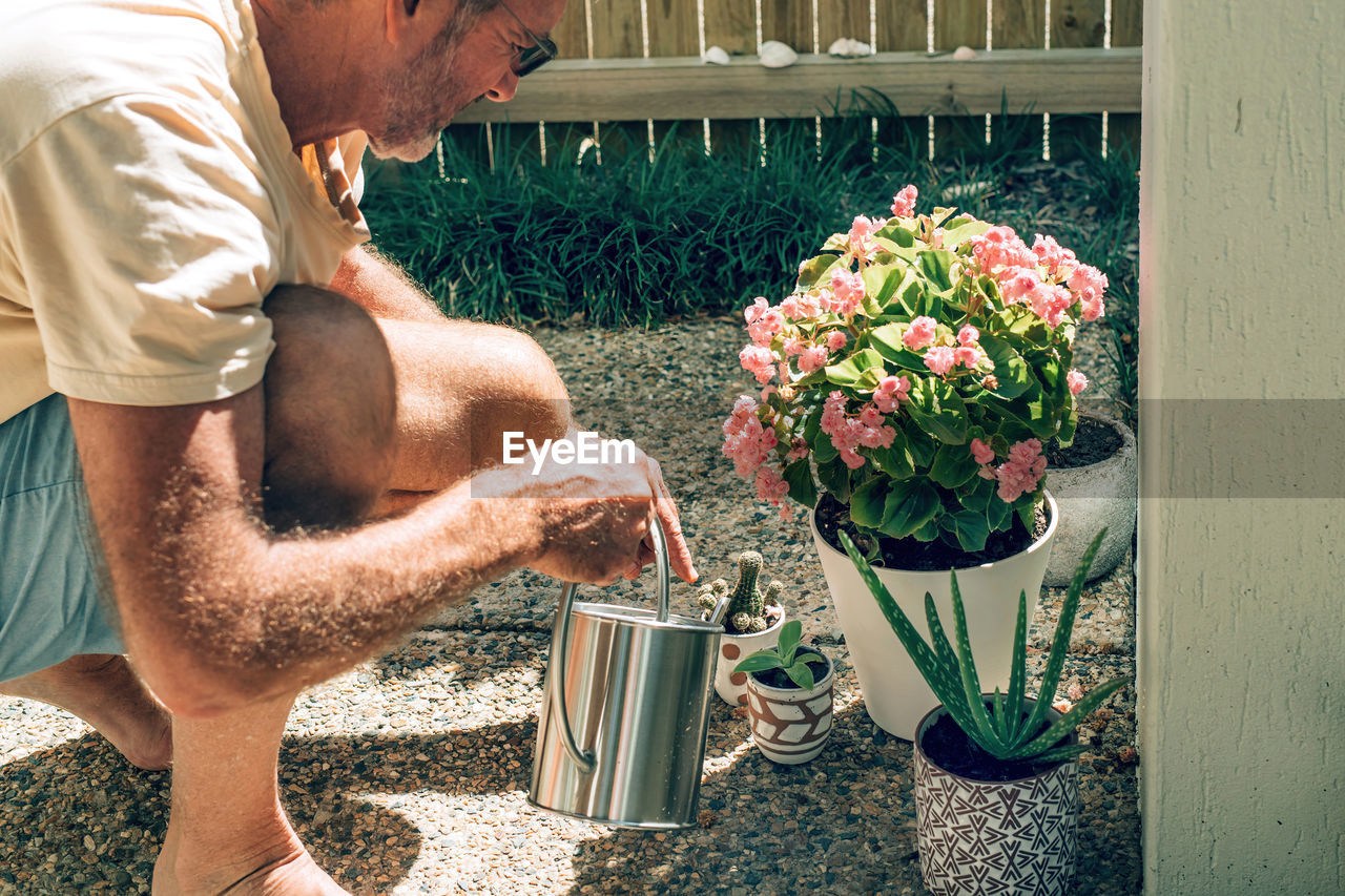 Midsection of man standing in flower pot