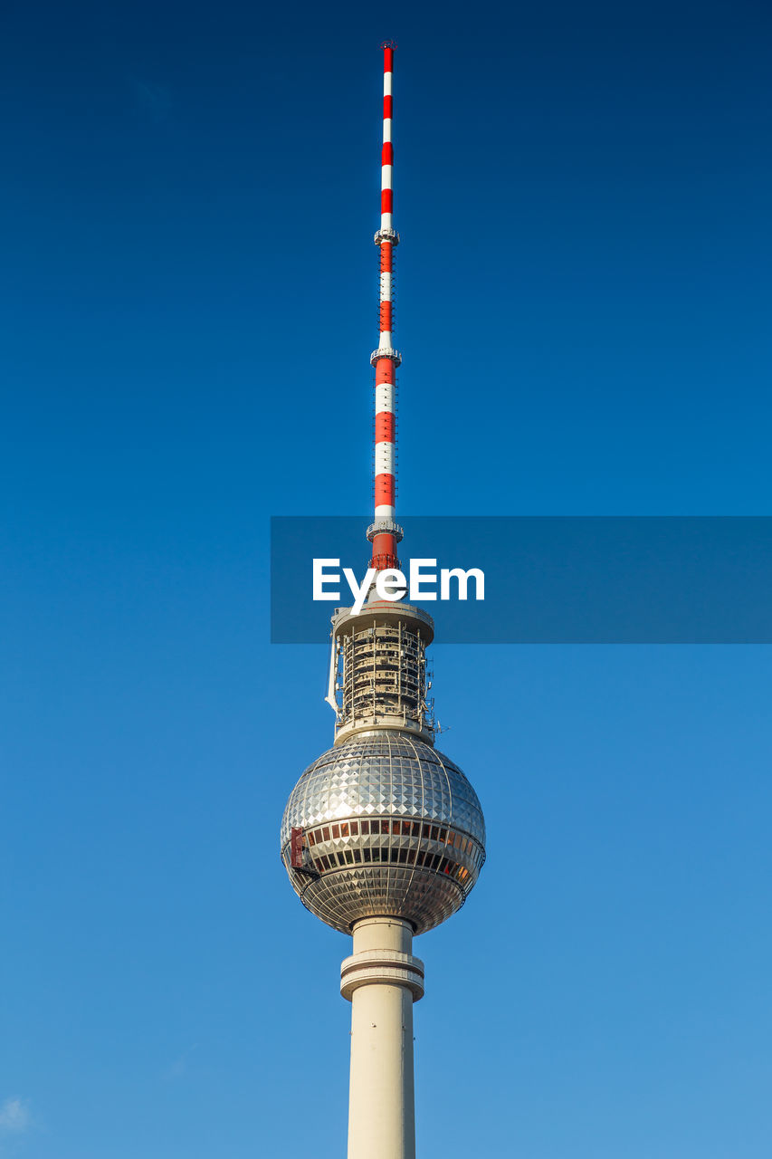 Low angle view of communications tower against blue sky