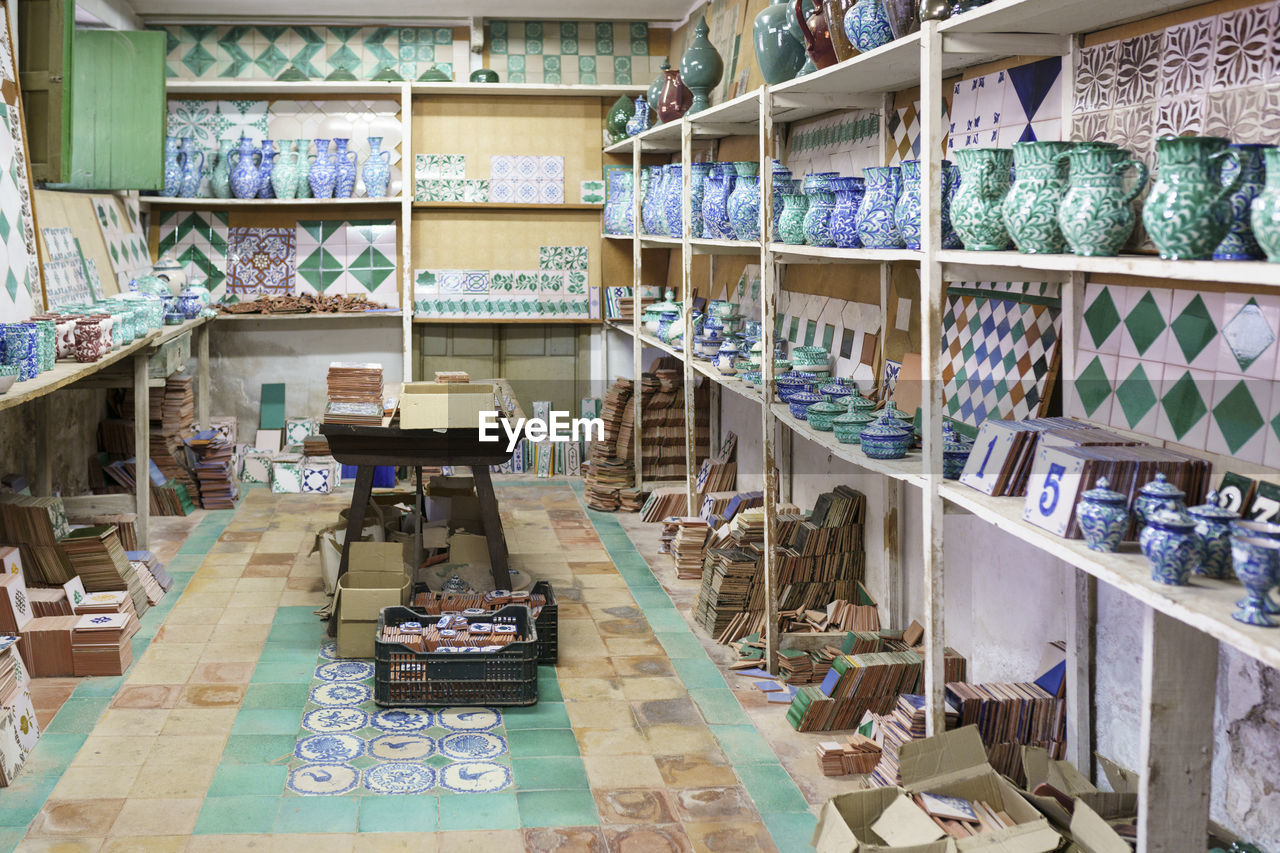 Various ceramic pieces arranged on rack in workshop