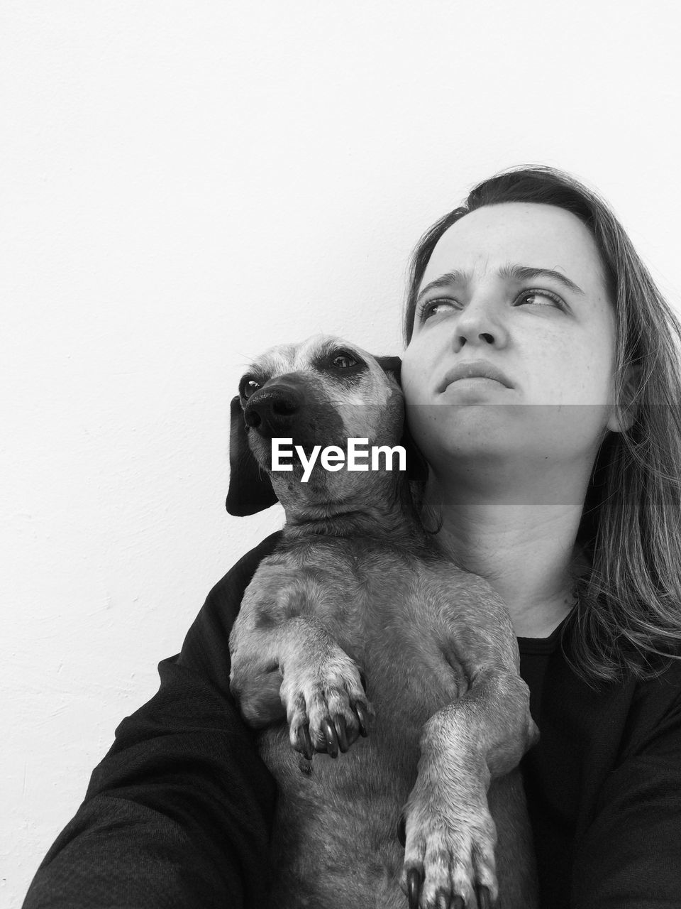 Low angle view of woman with dog looking away against white background