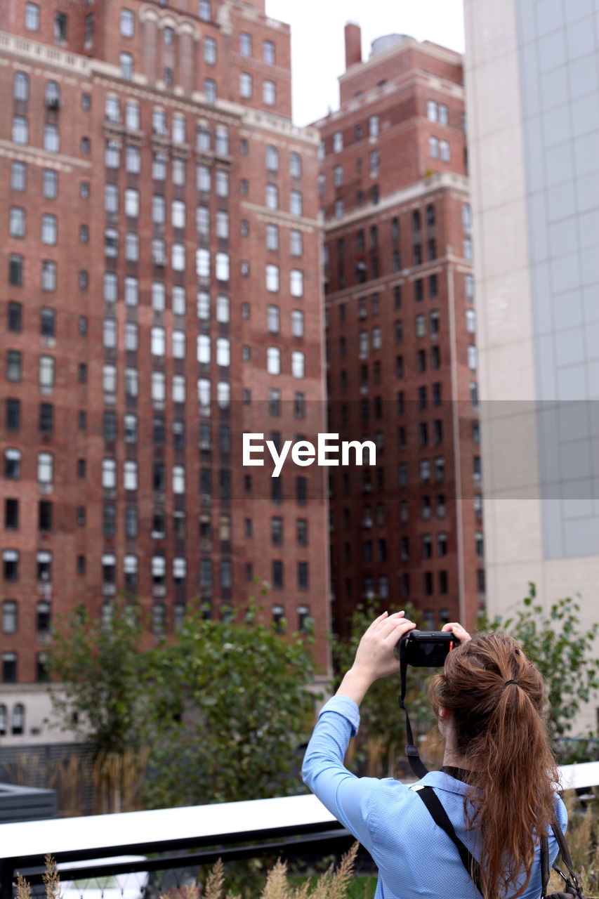 REAR VIEW OF MAN PHOTOGRAPHING