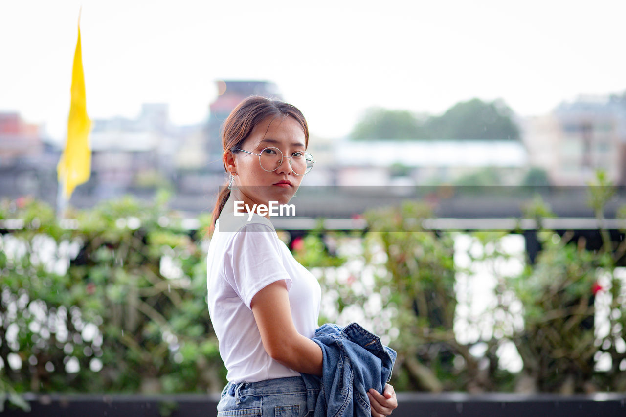 Portrait of woman standing in city