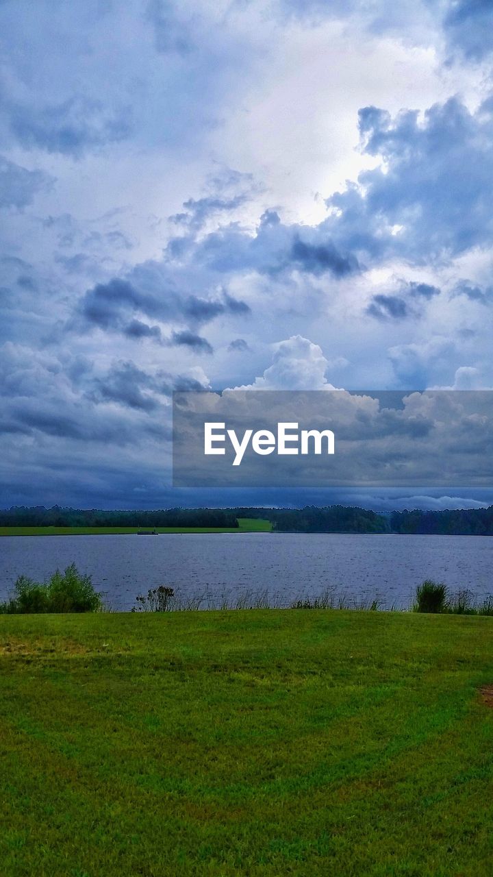 SCENIC VIEW OF LANDSCAPE AND LAKE AGAINST CLOUDY SKY