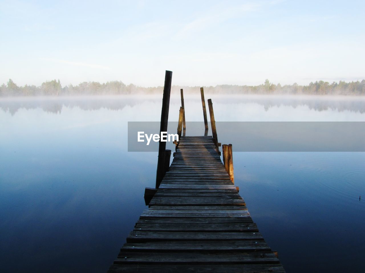 Pier over lake against clear sky