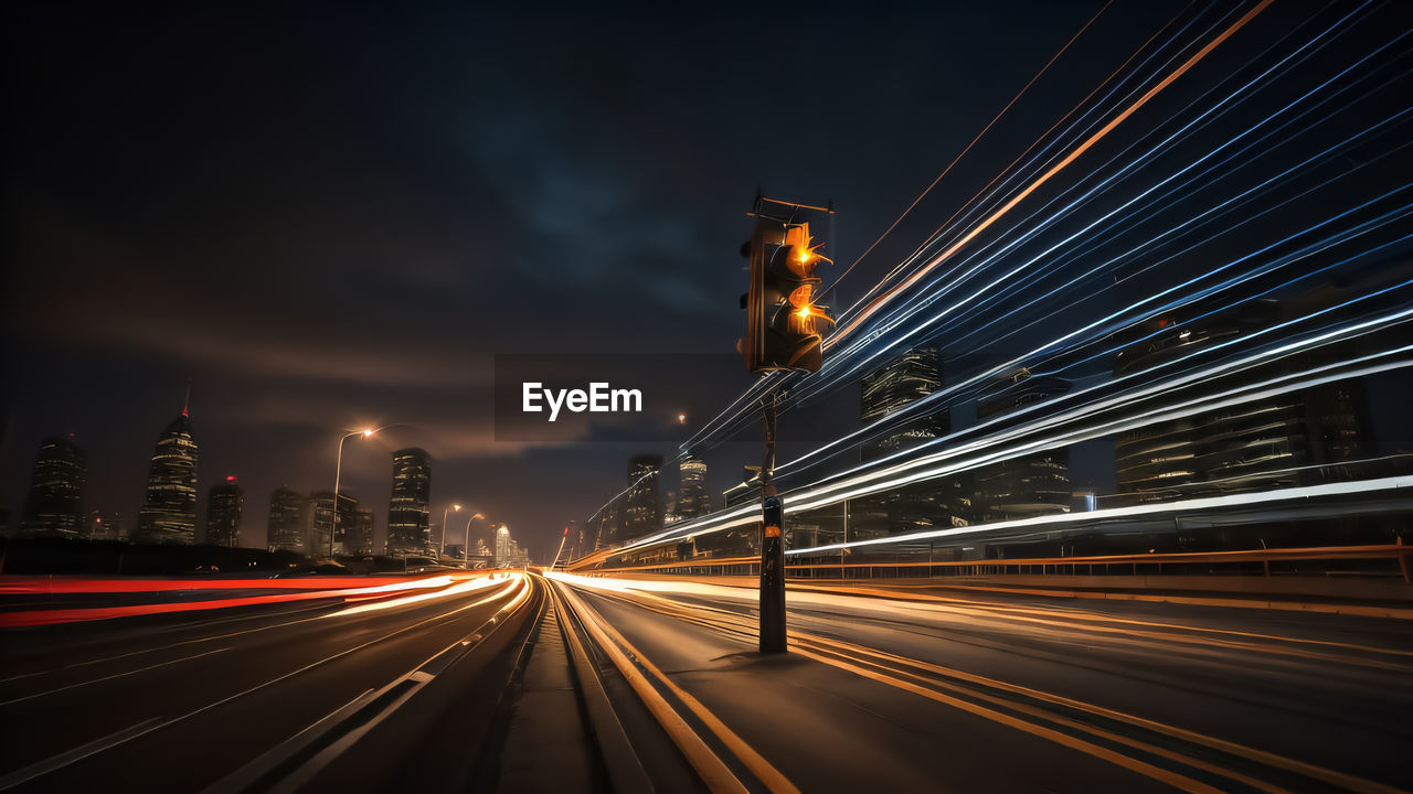 light trails on road against sky at night