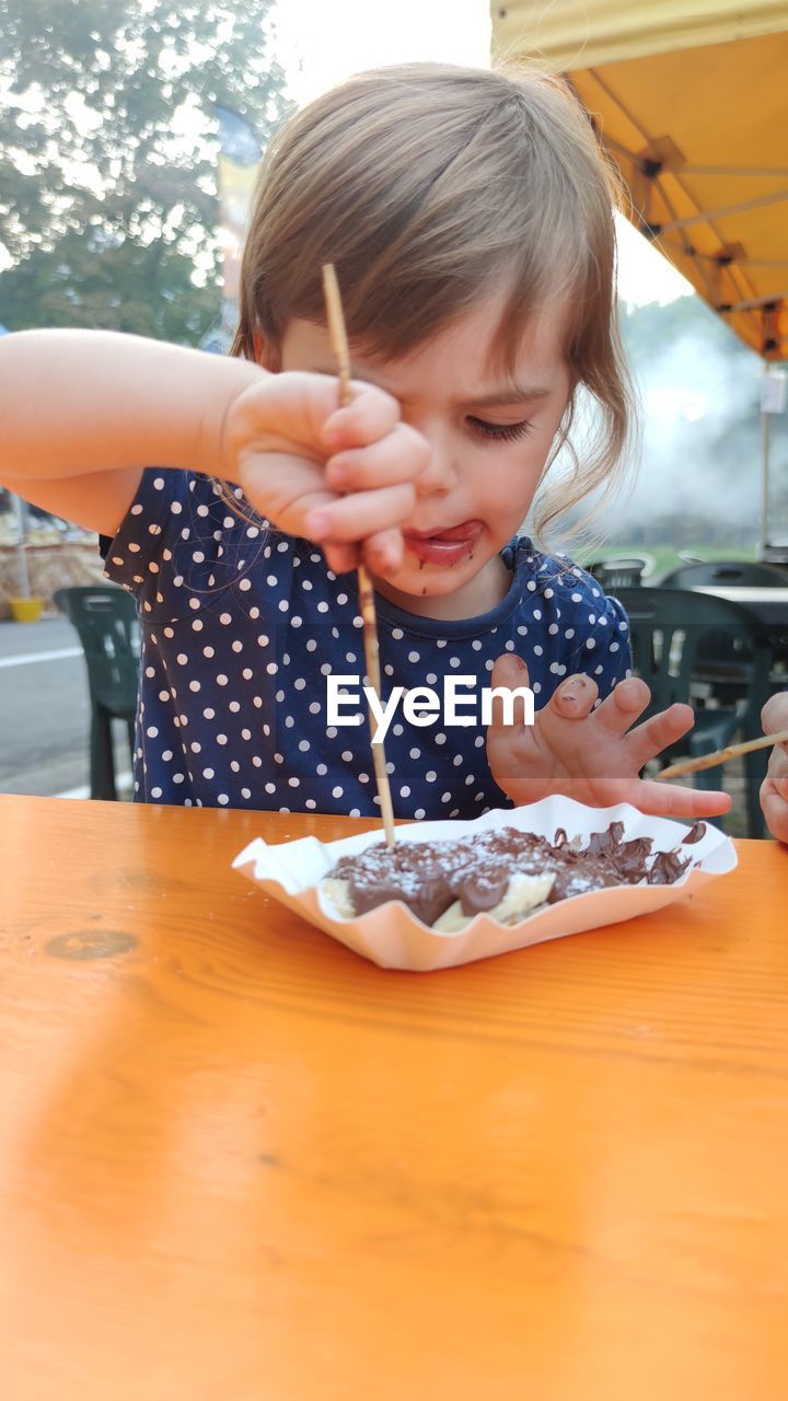 Portrait of cute girl eating dessert