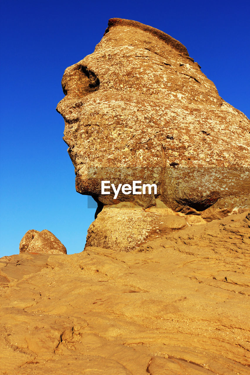 Low angle view of rocky landscape against clear sky