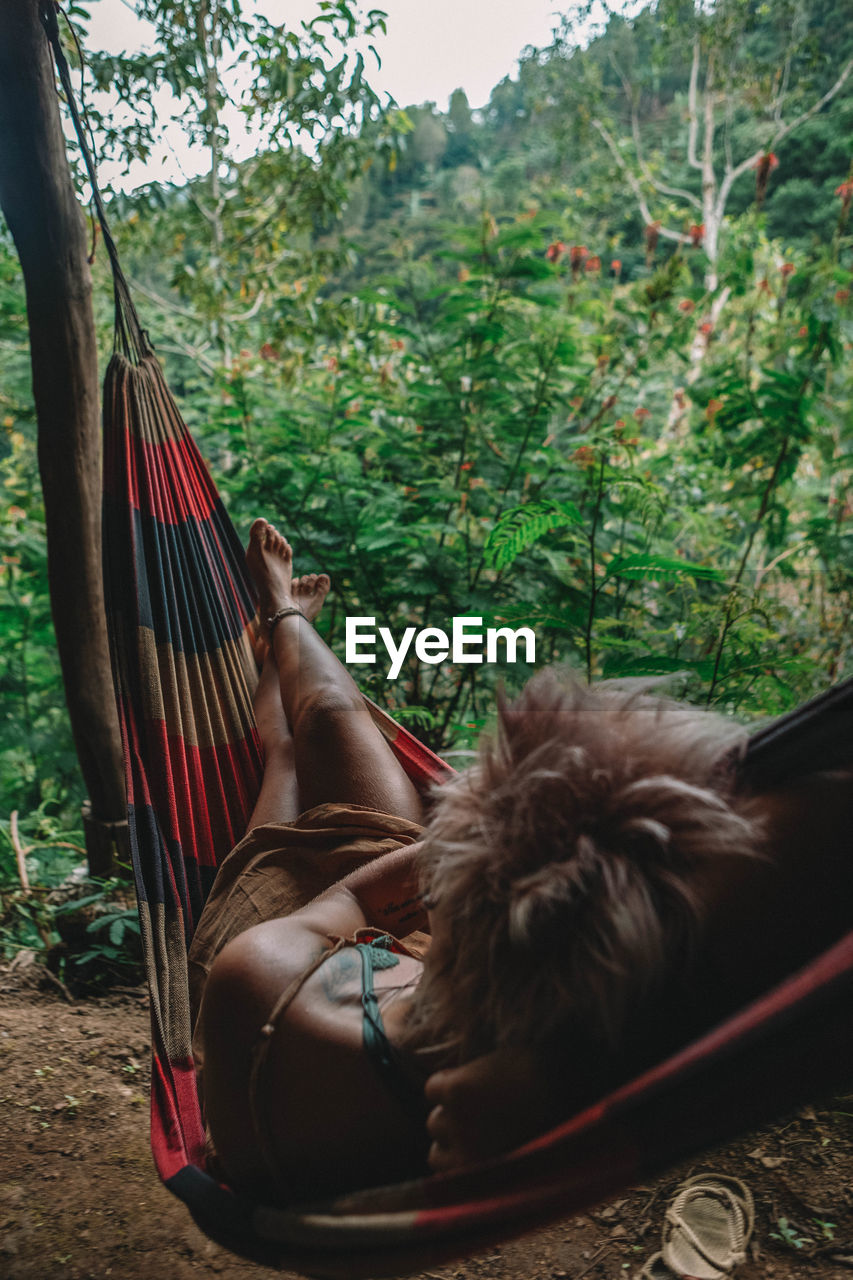 WOMAN SITTING ON HAMMOCK