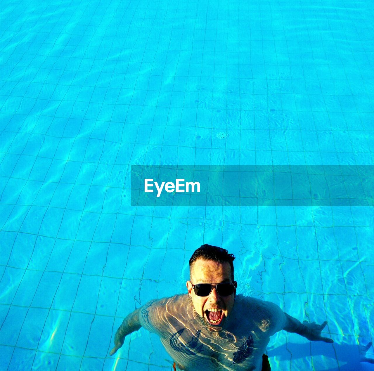 High angle view of young man swimming in pool