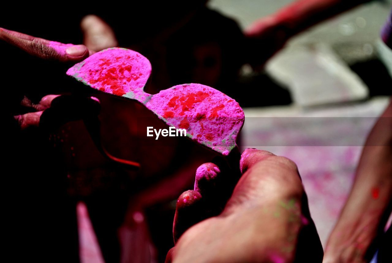 Cropped image of man holding pink powdered sunglasses