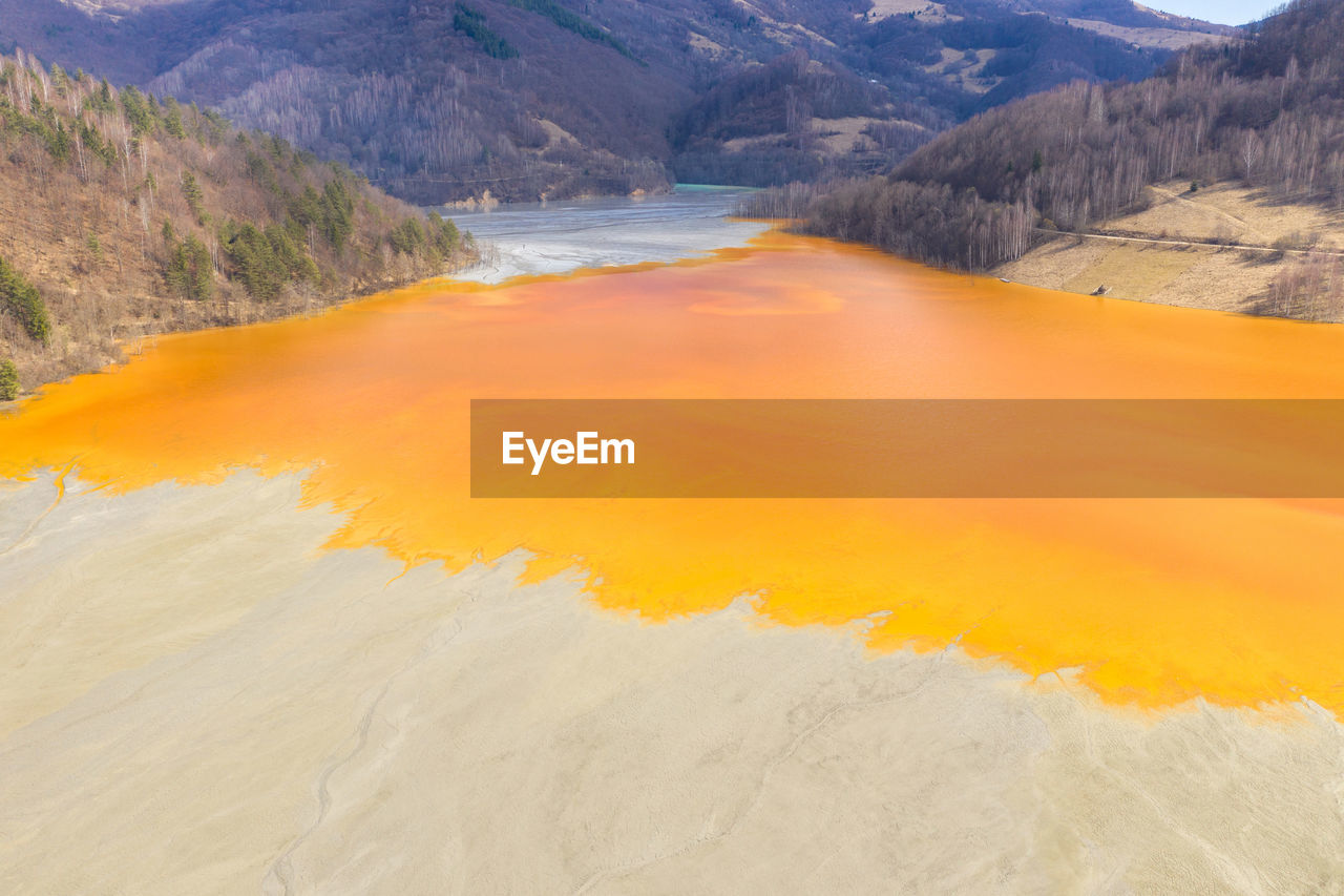 Colorful lake polluted with yellow waste water, aerial view of a mining decanting pond 