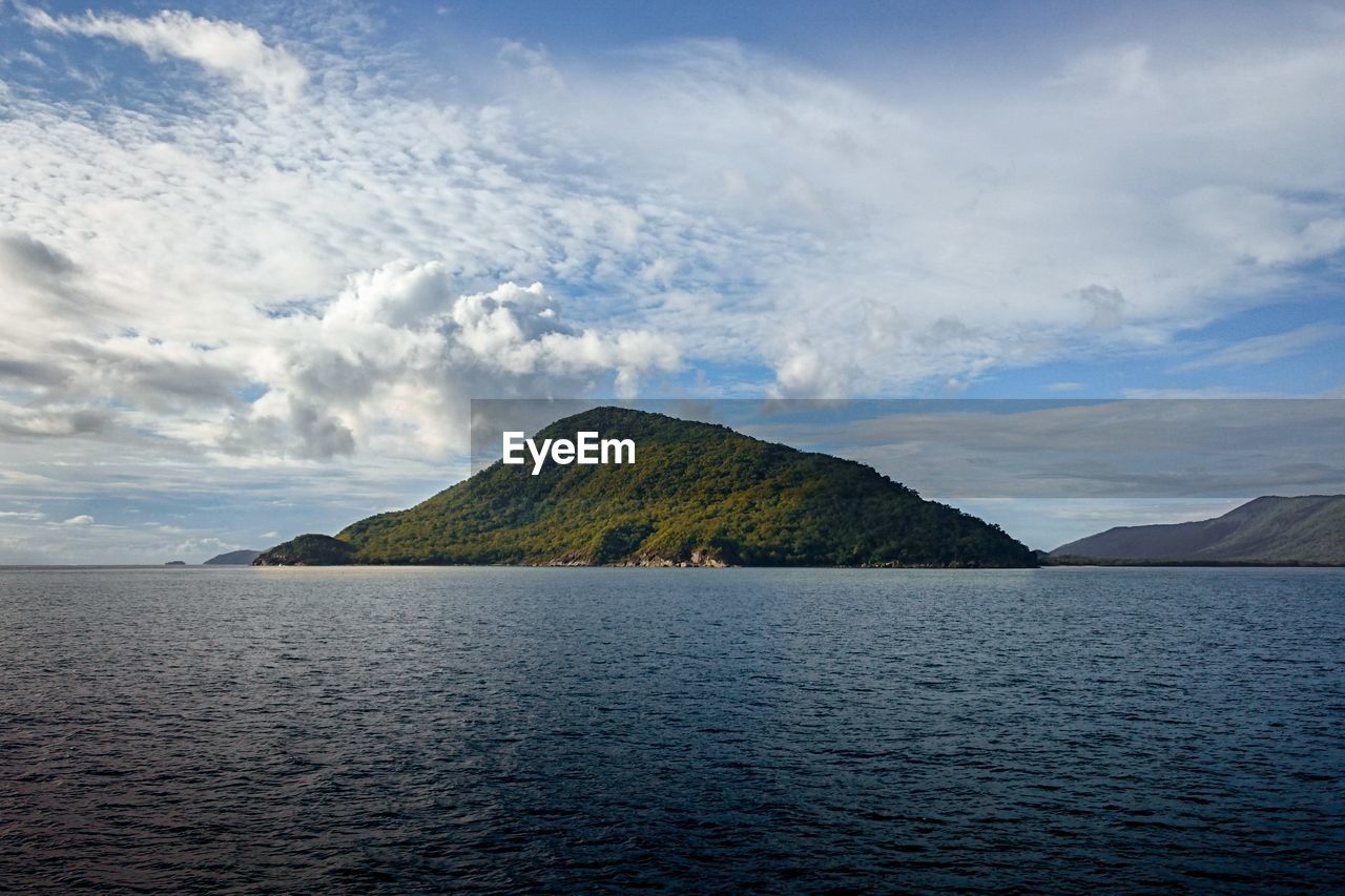 Perfectly placed green island framed by the sea and sky