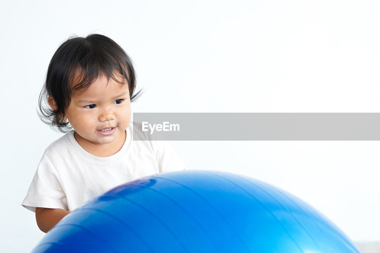 child, childhood, one person, happiness, smiling, portrait, toddler, person, cute, emotion, baby, cheerful, men, copy space, indoors, white background, positive emotion, fun, looking at camera, blue, clothing, ball, studio shot, lifestyles, joy, cut out, innocence, human face, white