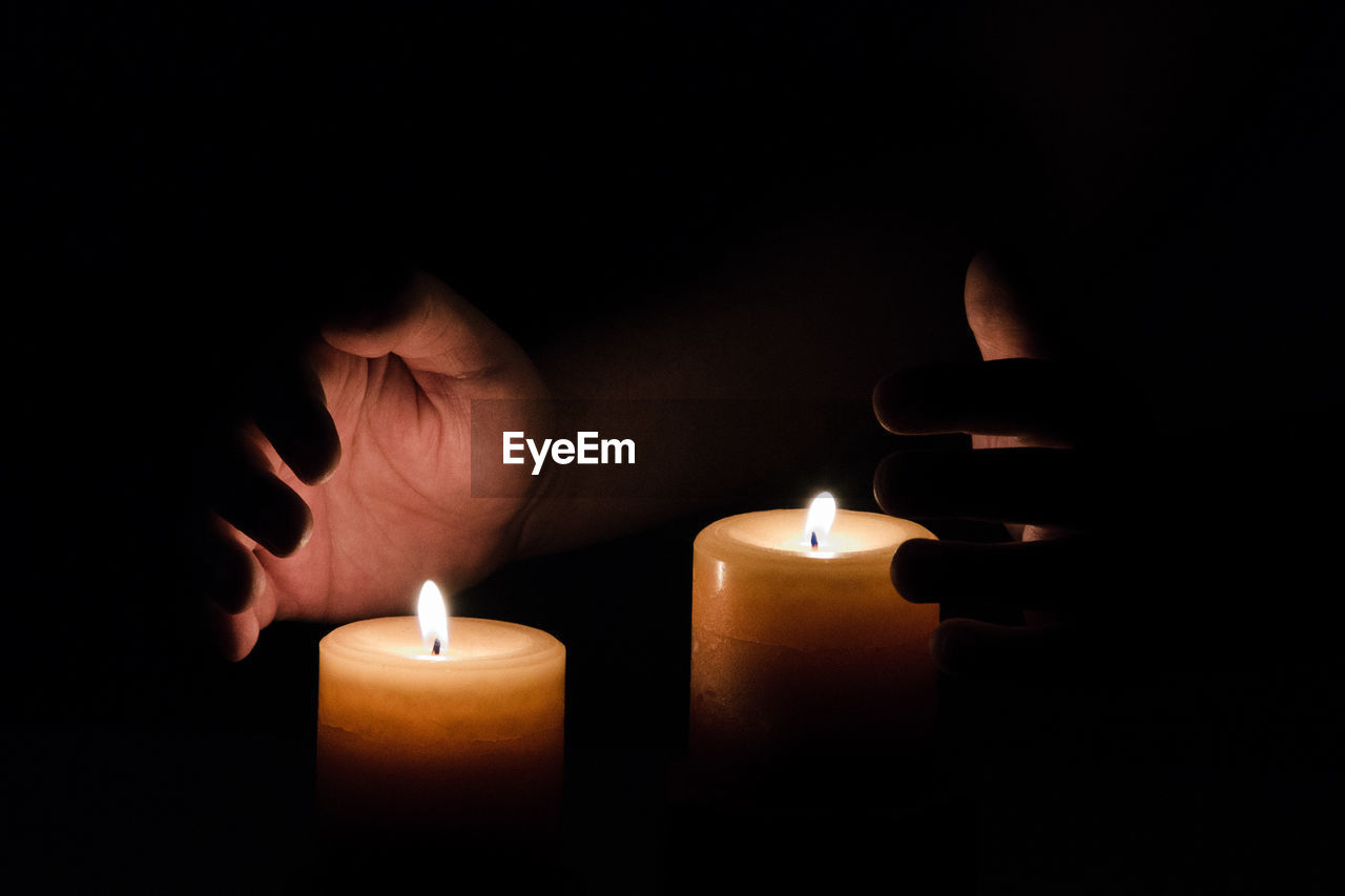 Close-up of lit candle in darkroom