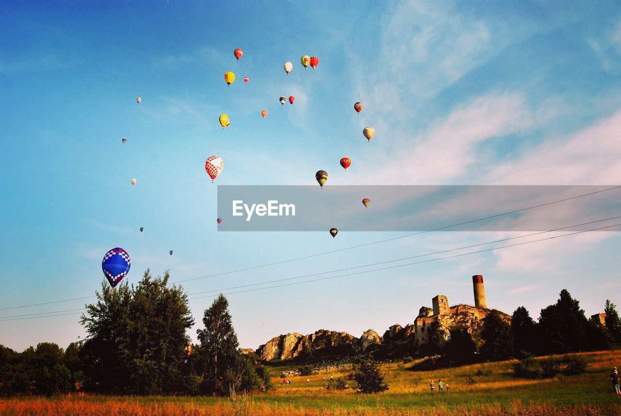 LOW ANGLE VIEW OF HOT AIR BALLOONS ON FIELD