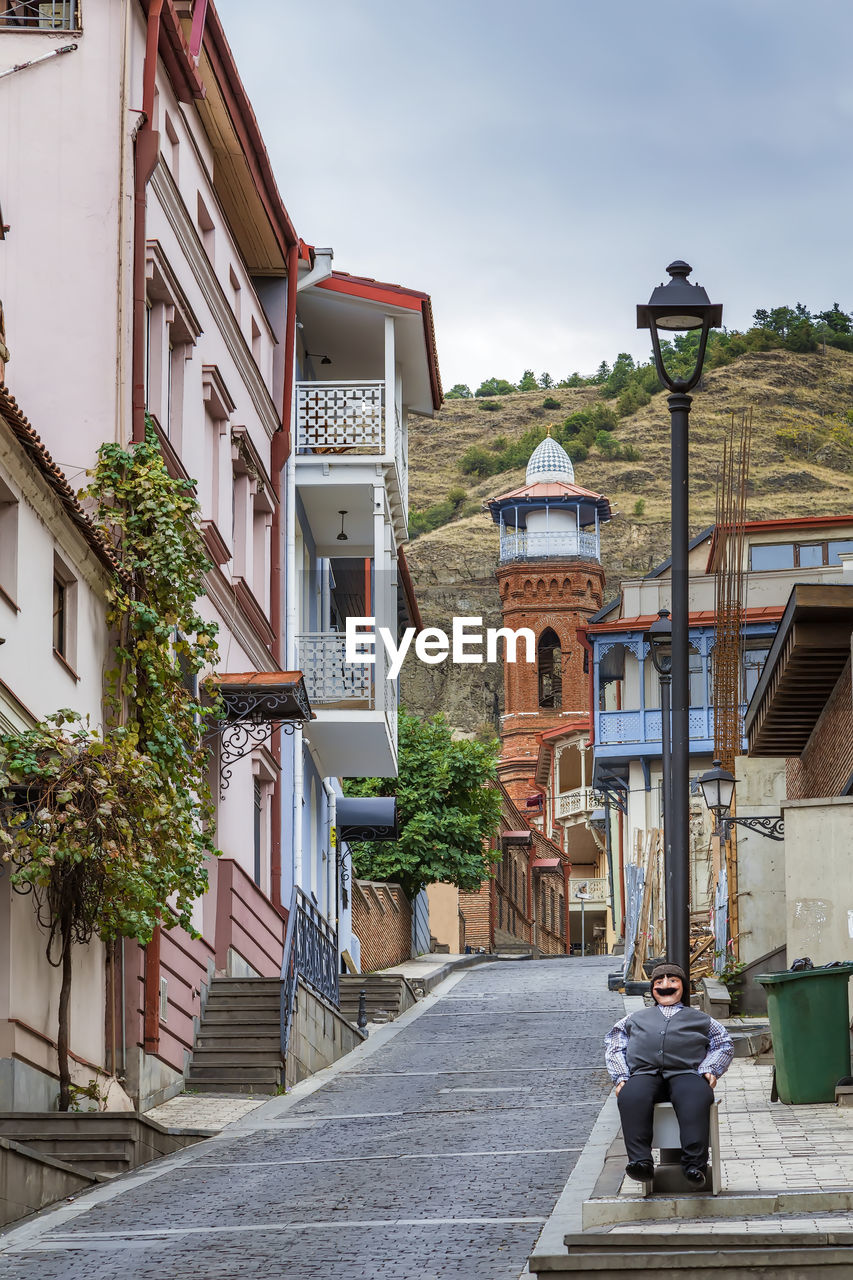 STREET AMIDST HOUSES AGAINST SKY