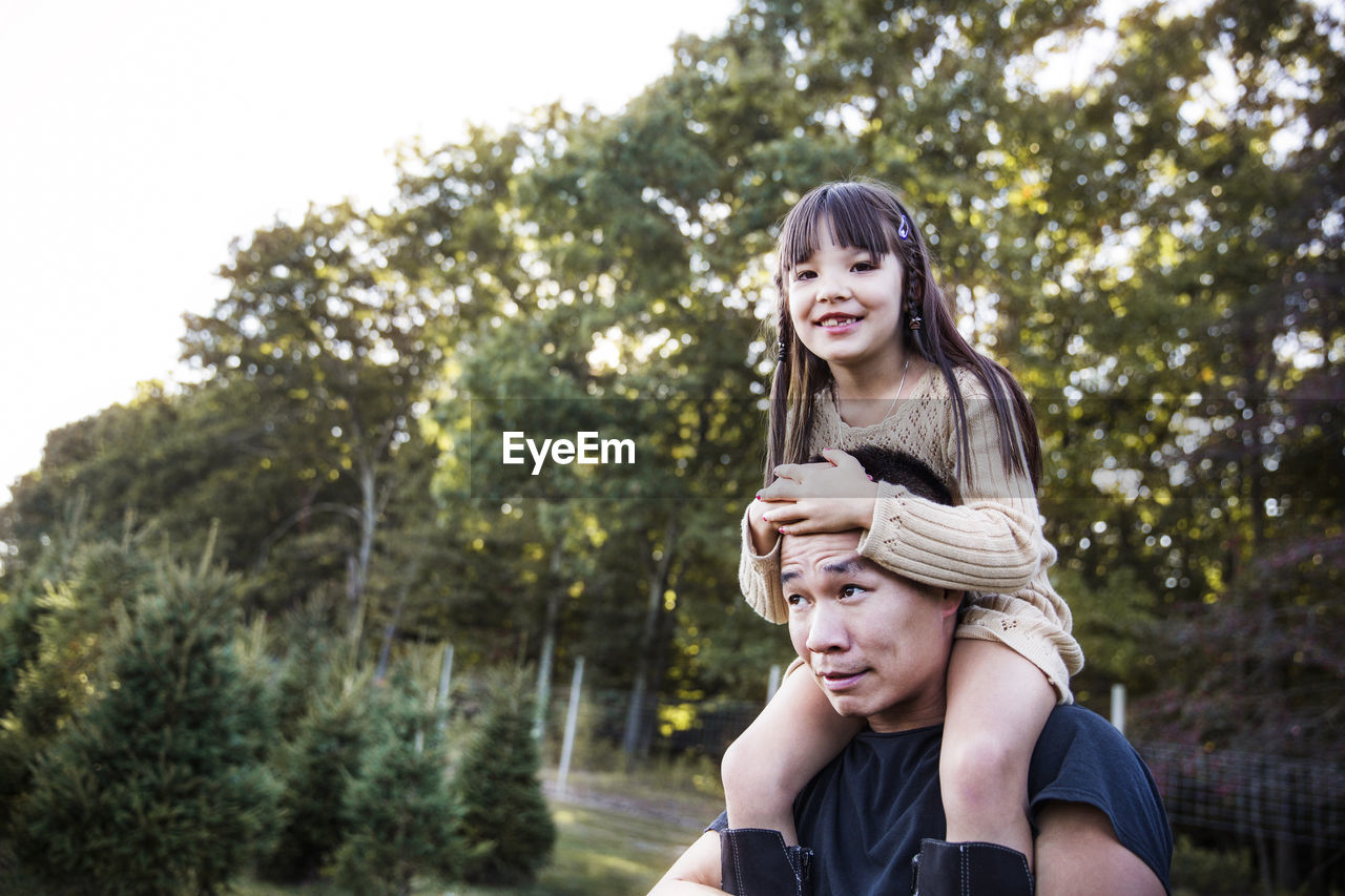 Father carrying daughter on shoulders