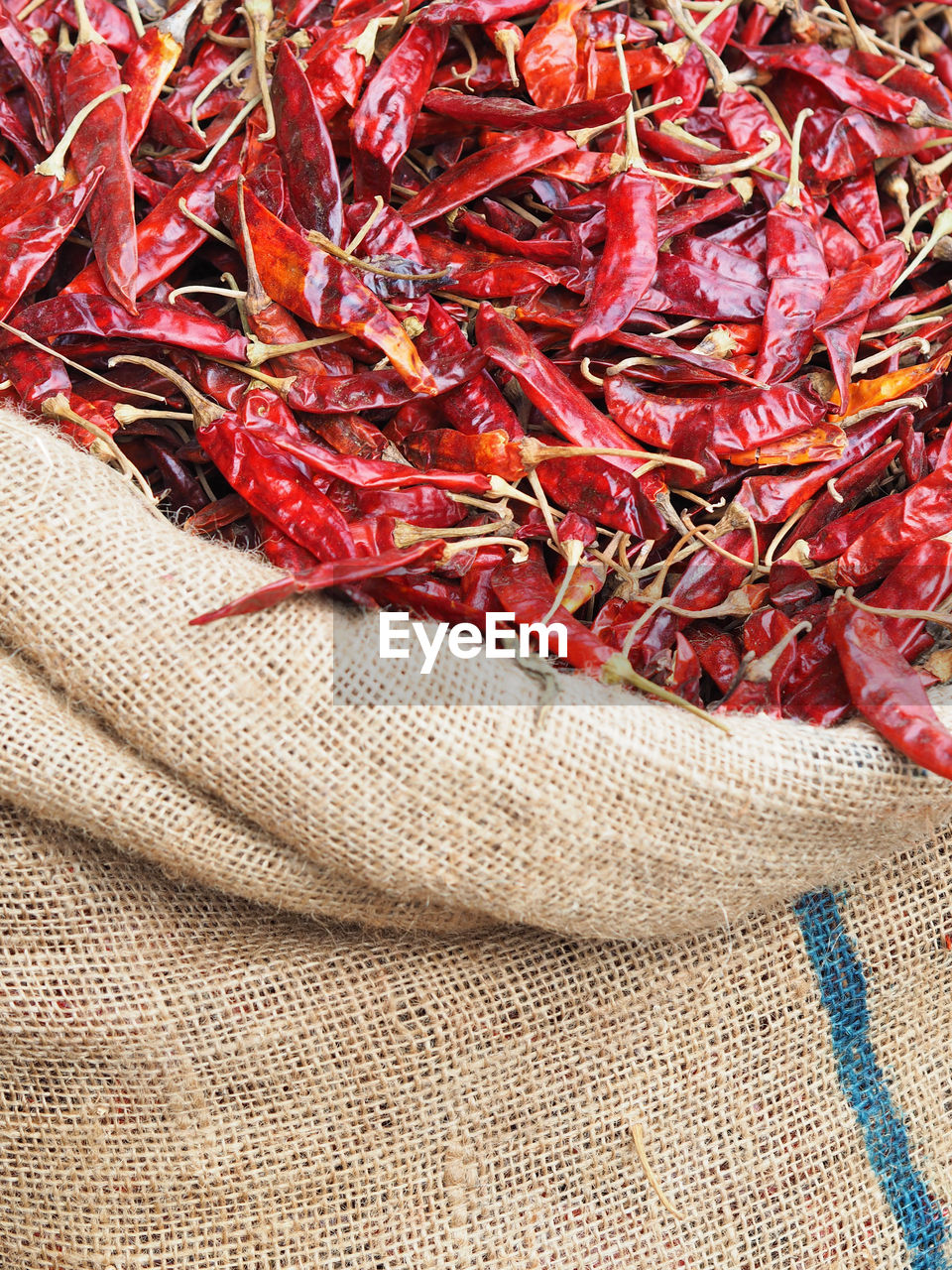 High angle view of dried red chili pepper in sack at market