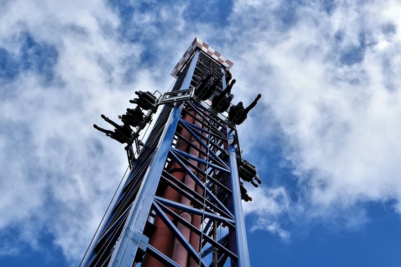 Low angle view of people enjoying ride against sky