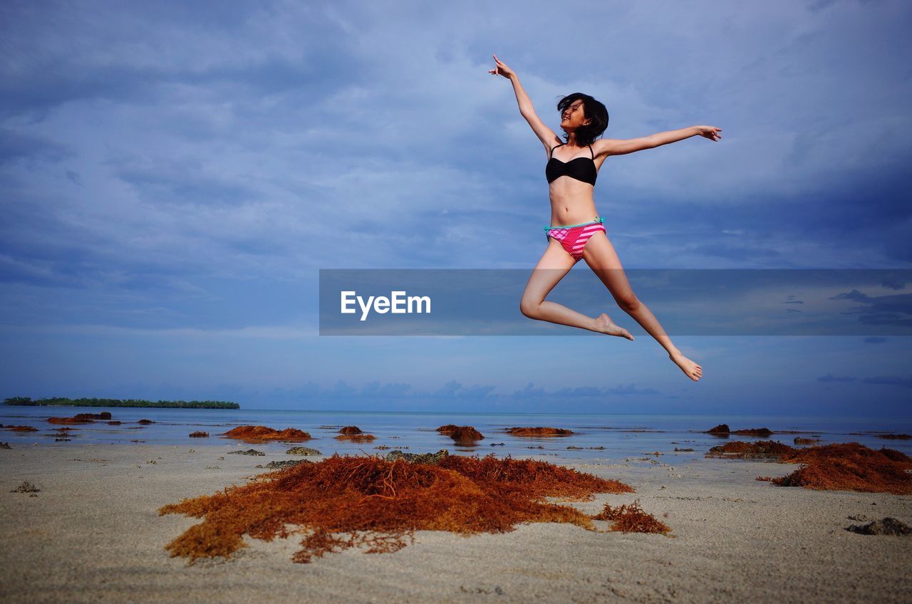 Woman jumping on shore