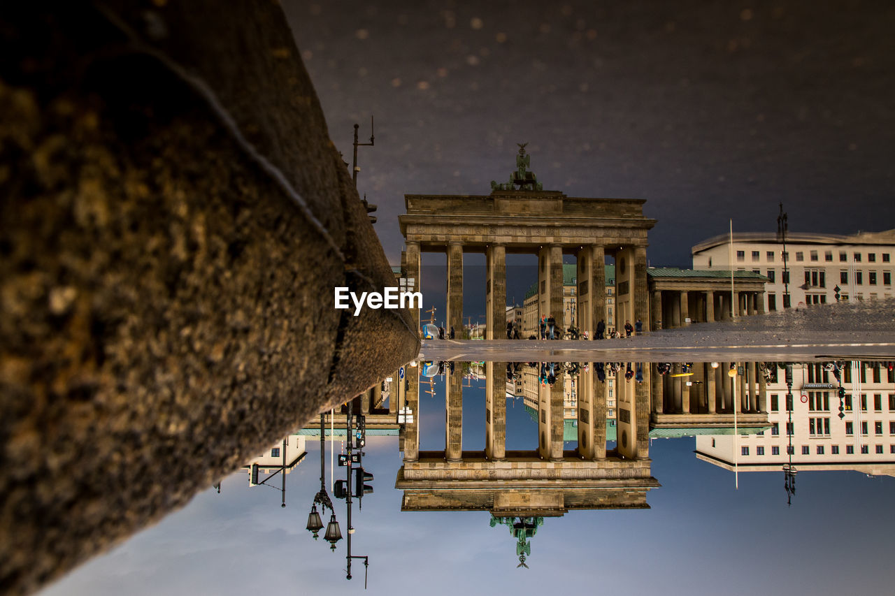 Reflection of brandenburg gate in puddle on street