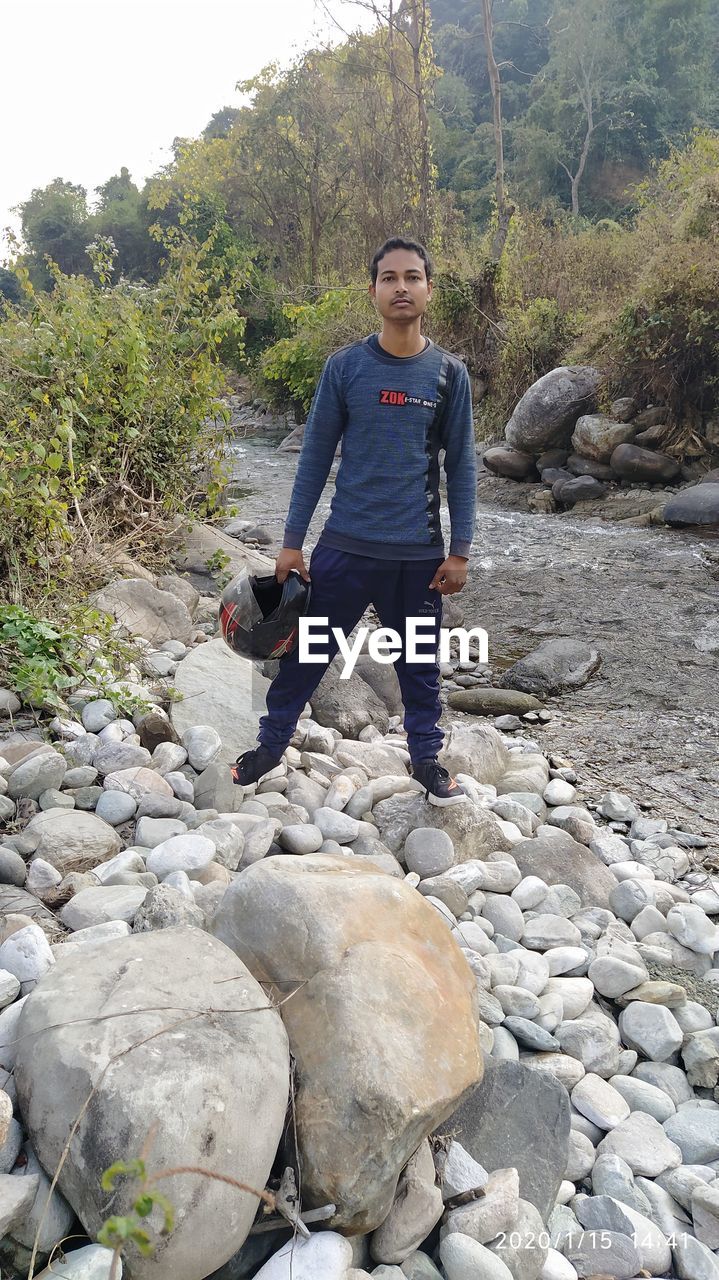 FULL LENGTH OF MAN STANDING ON ROCK