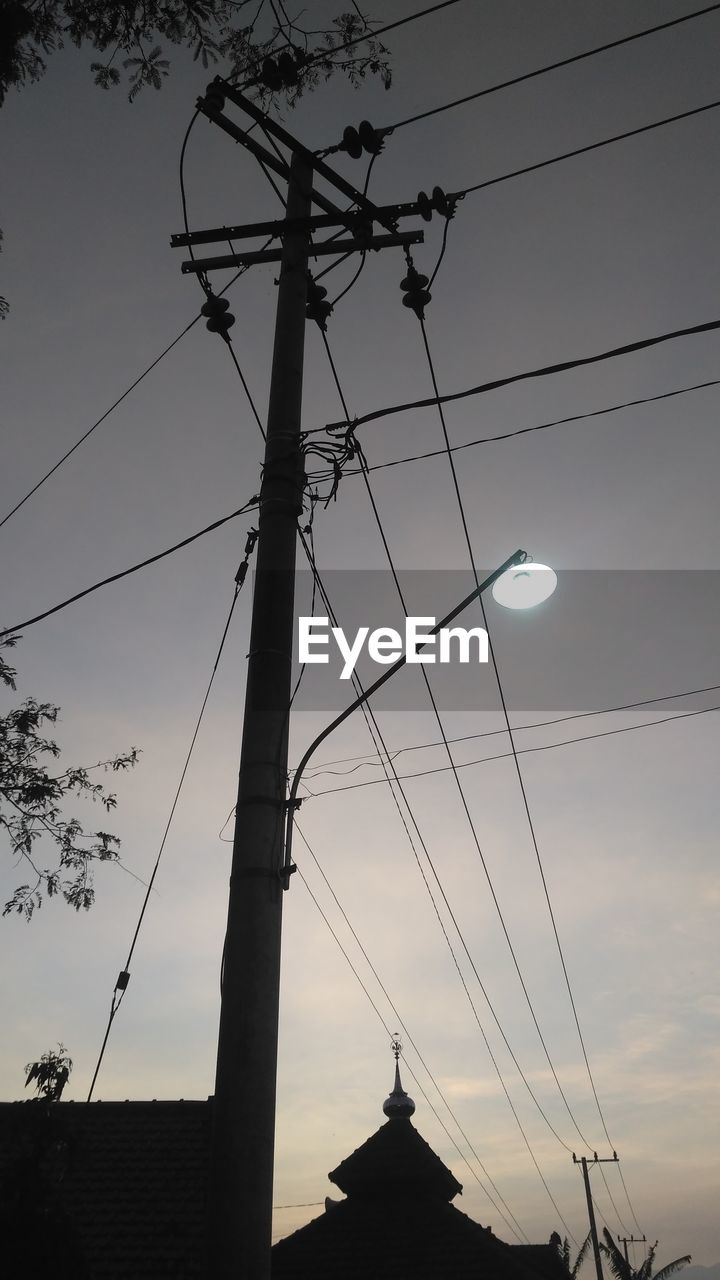 LOW ANGLE VIEW OF SILHOUETTE ELECTRICITY PYLONS AGAINST SKY