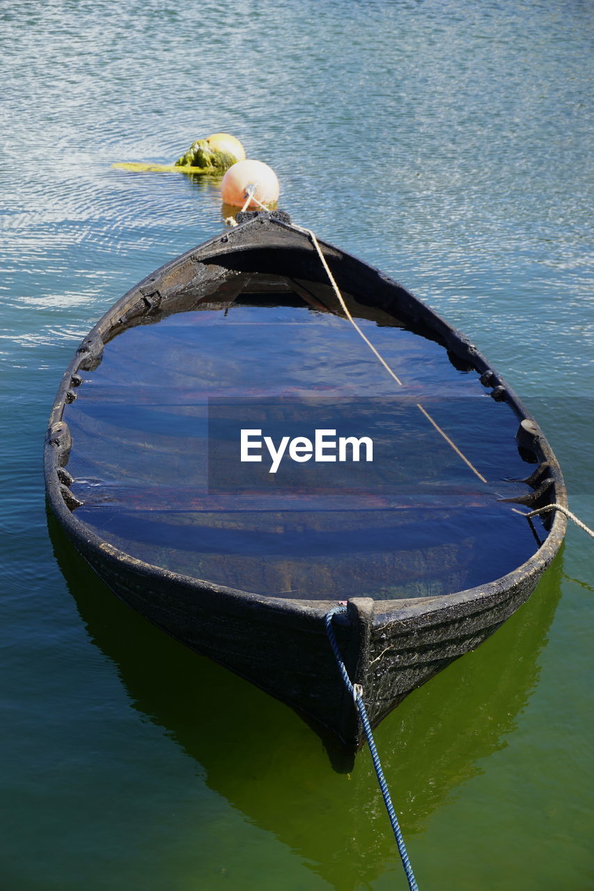 HIGH ANGLE VIEW OF BIRD PERCHING ON BOAT IN WATER