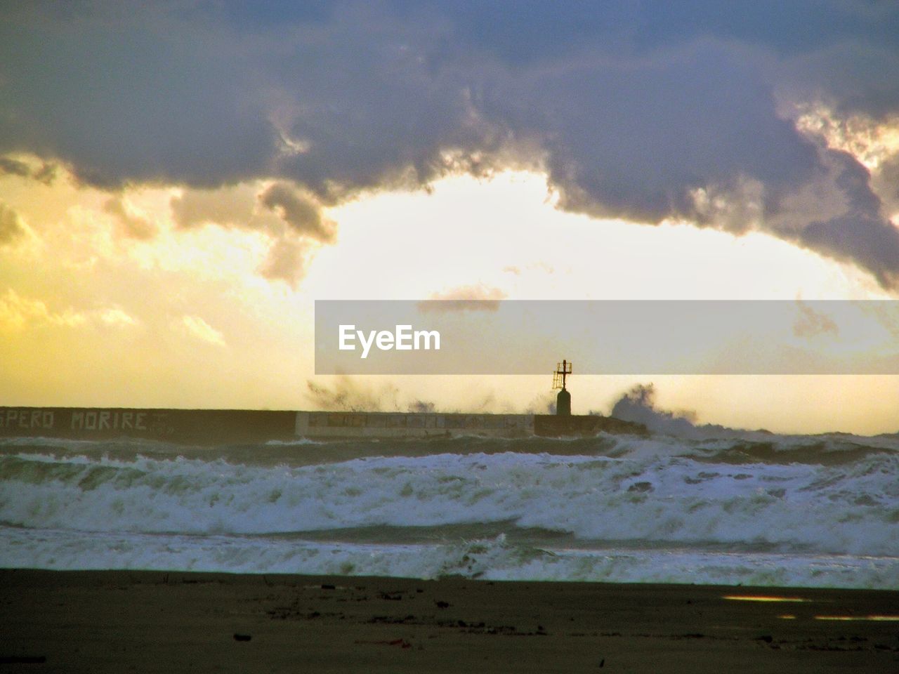 Scenic view of landscape against cloudy sky during sunset