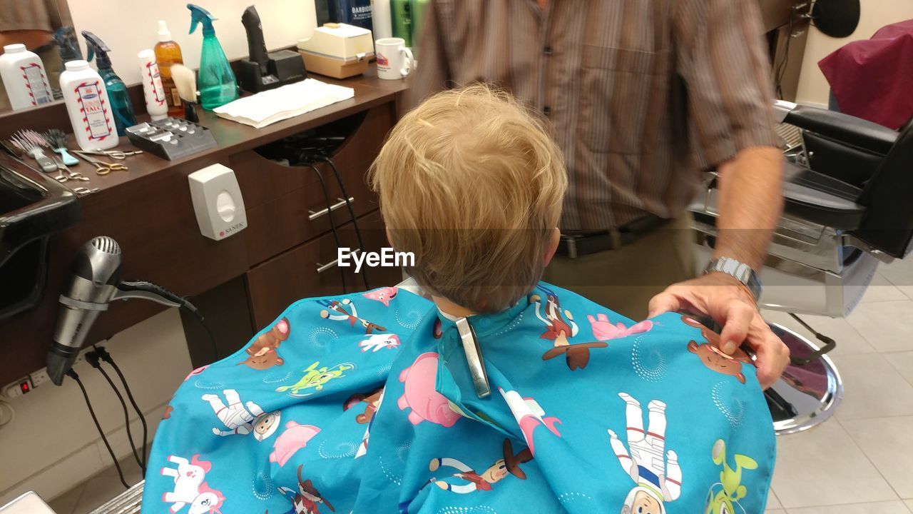 REAR VIEW OF BOY STANDING ON FLOOR