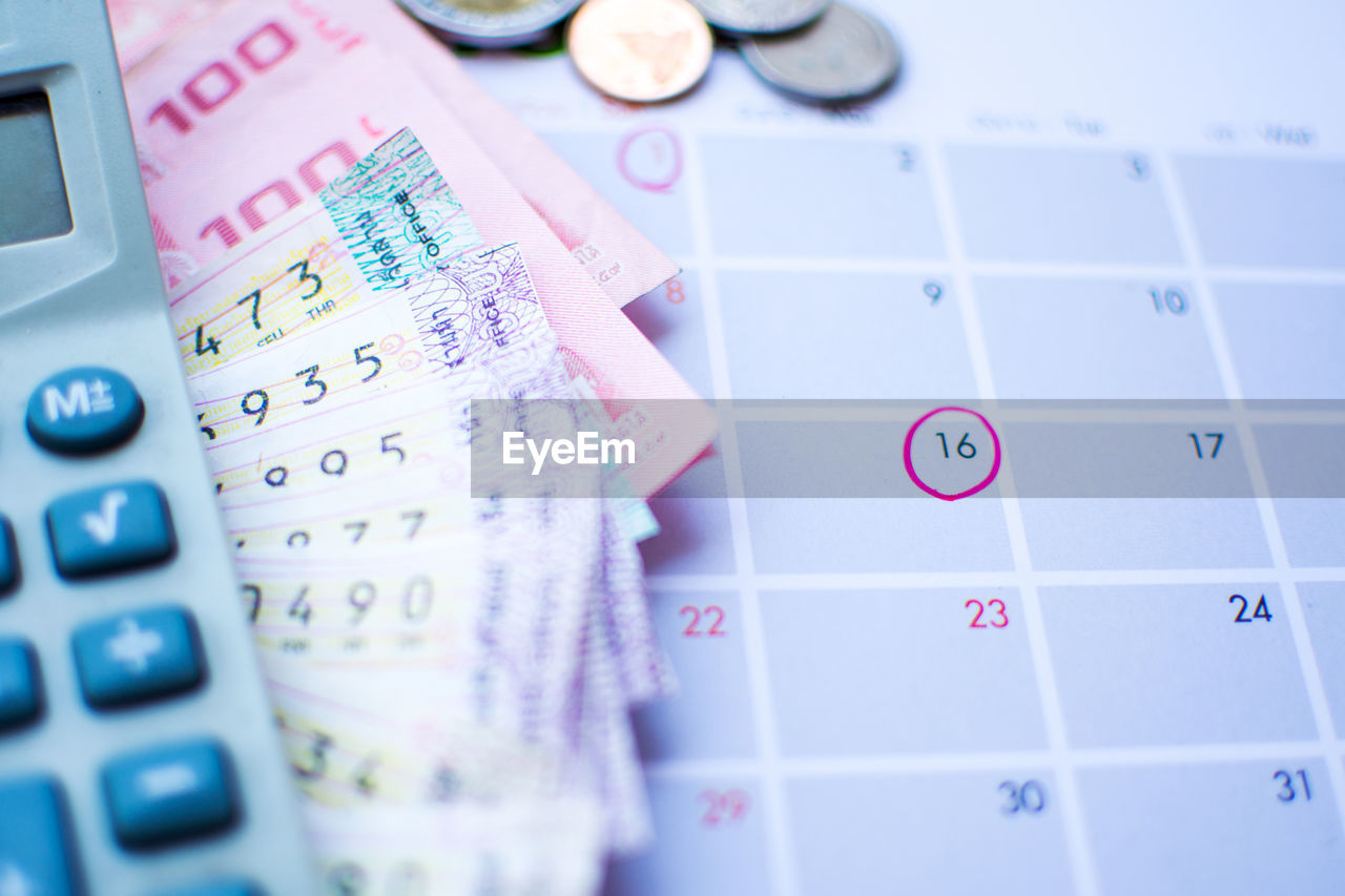 High angle view of paper currency on calendar