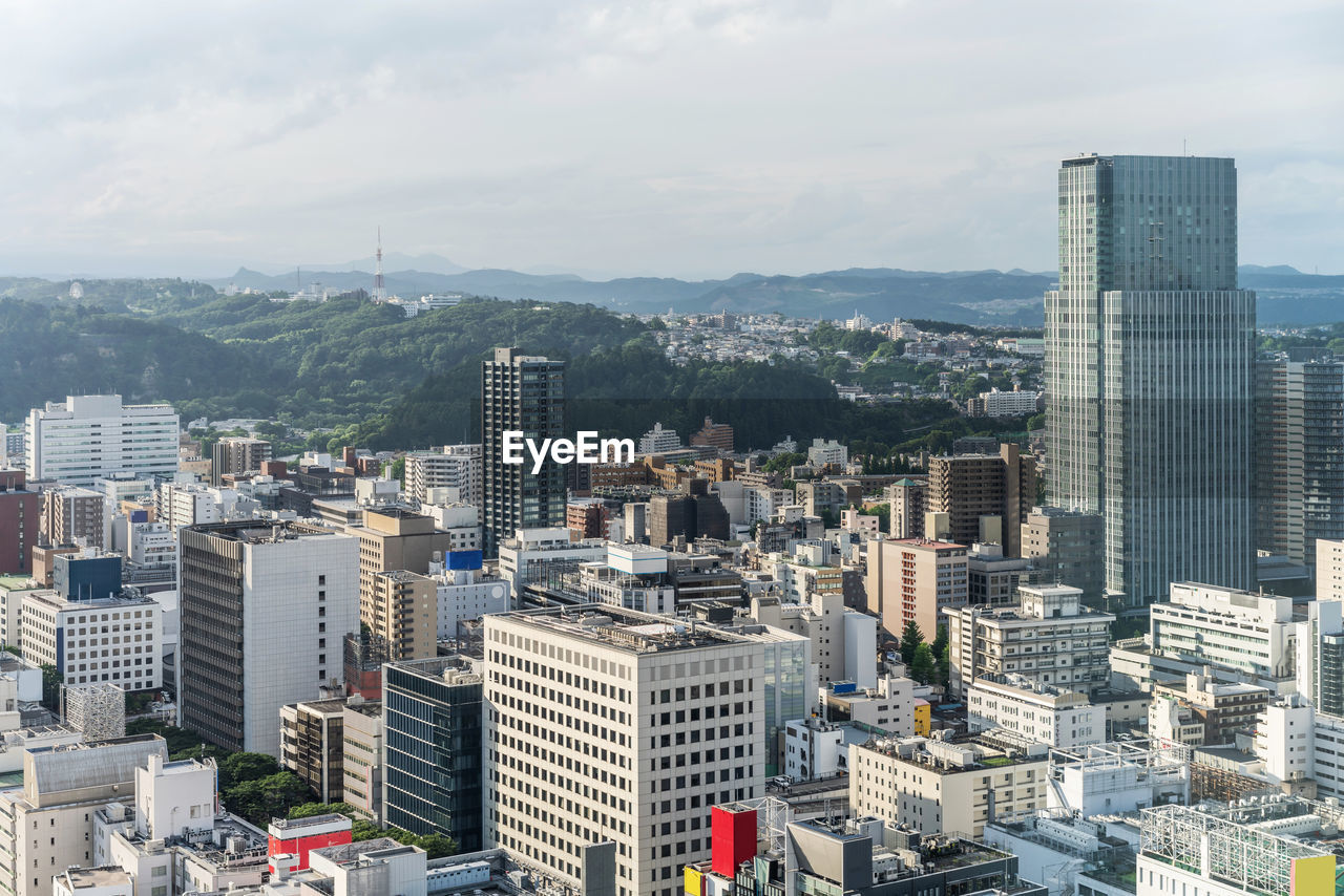 AERIAL VIEW OF BUILDINGS AGAINST CLOUDY SKY