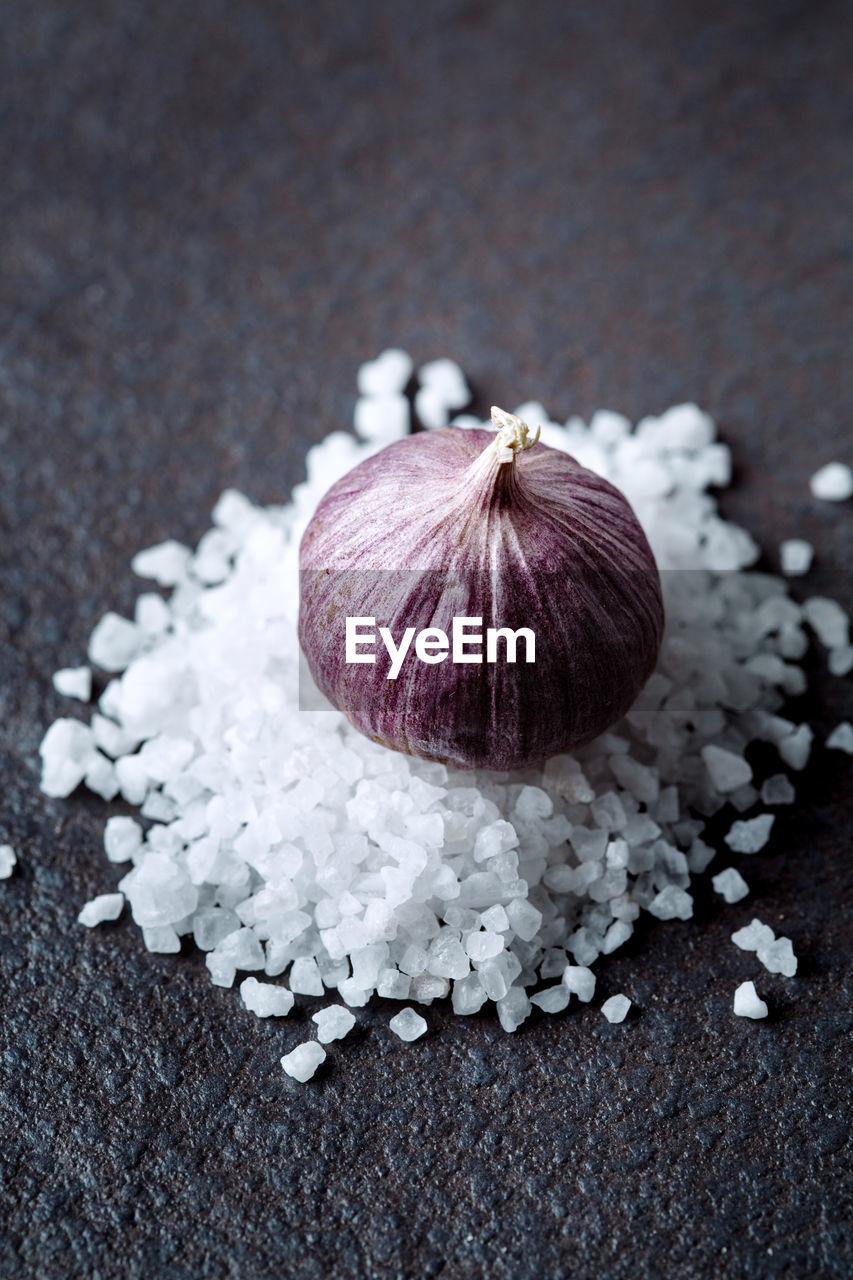 Garlic bulb on salt heap close-up, selective focus
