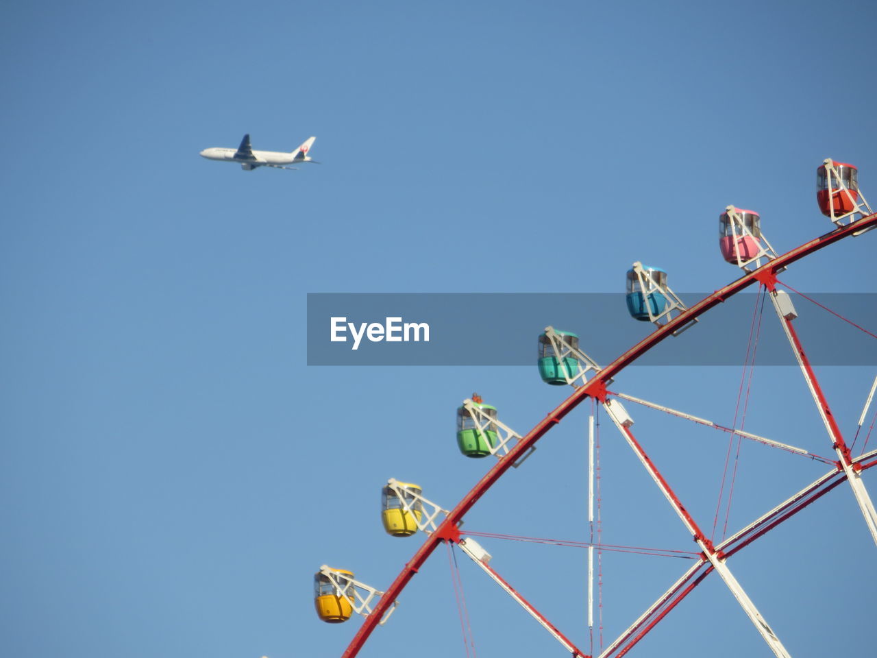 LOW ANGLE VIEW OF AIRPLANE AGAINST CLEAR BLUE SKY