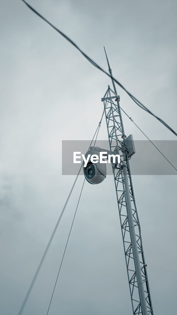 Low angle view of electricity pylon against sky