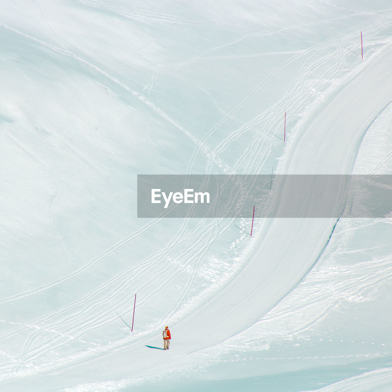 High angle view of man walking on snow covered land