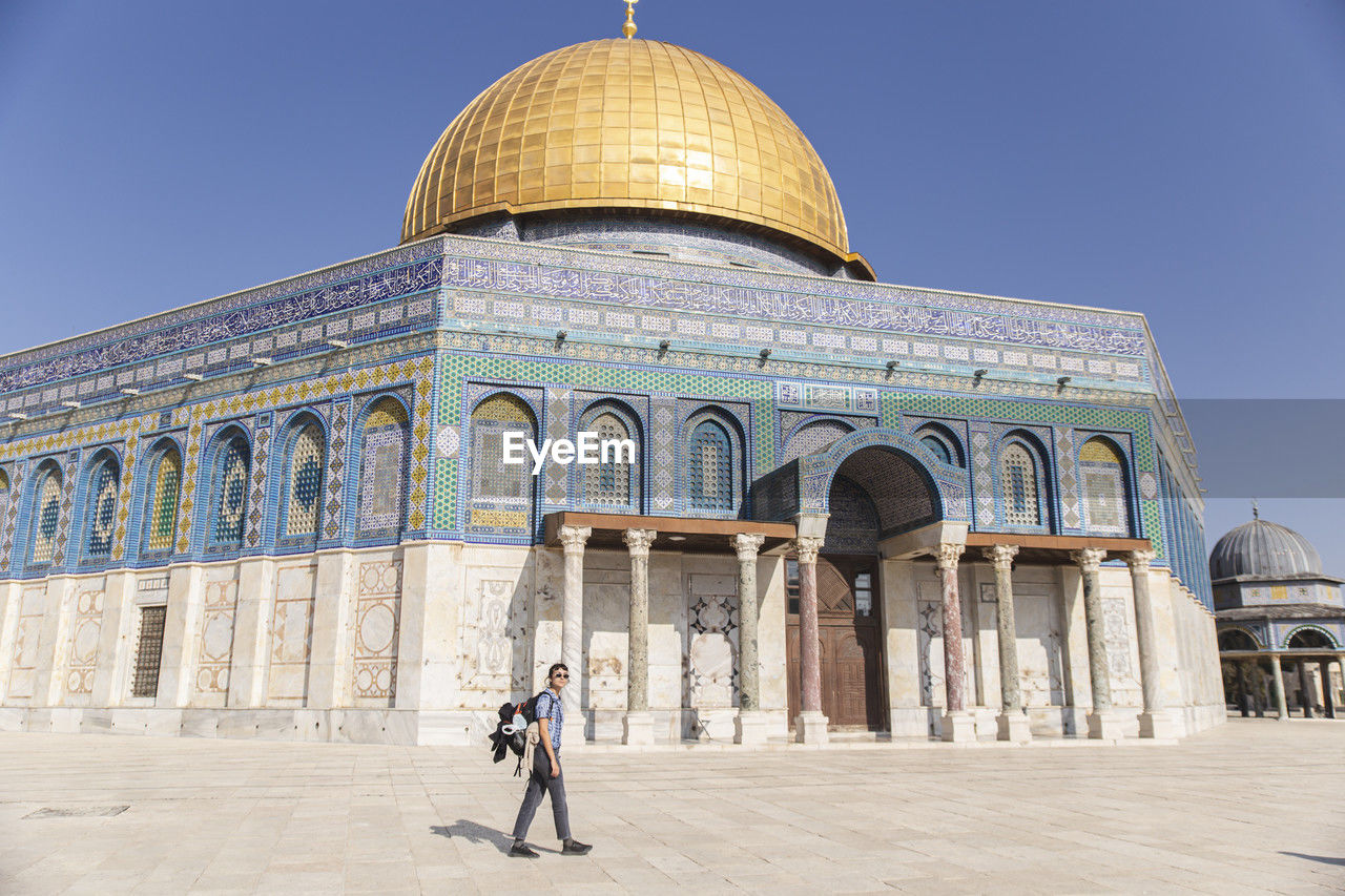 Young woman walking in front of al-aqsa mosque, jerusalem, israel