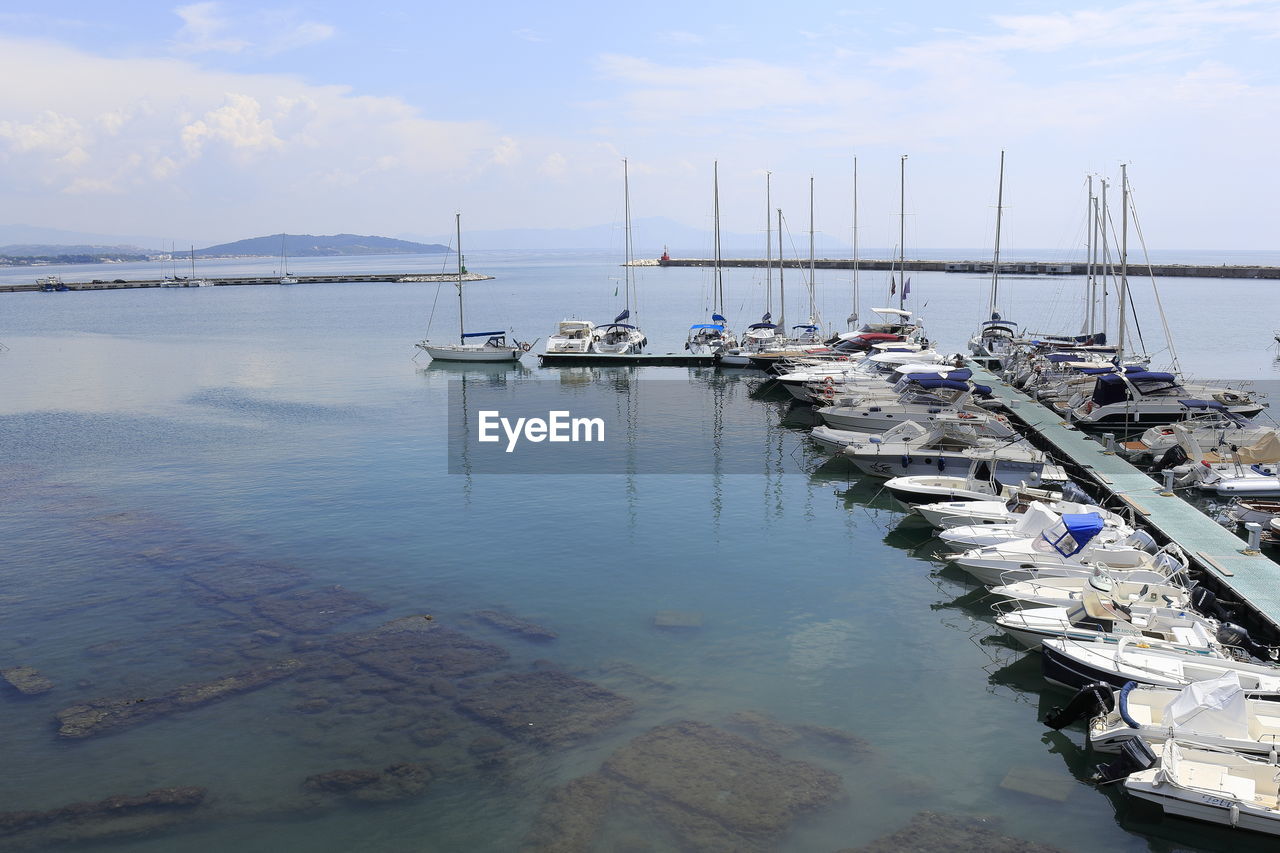 Sailboats moored in harbor