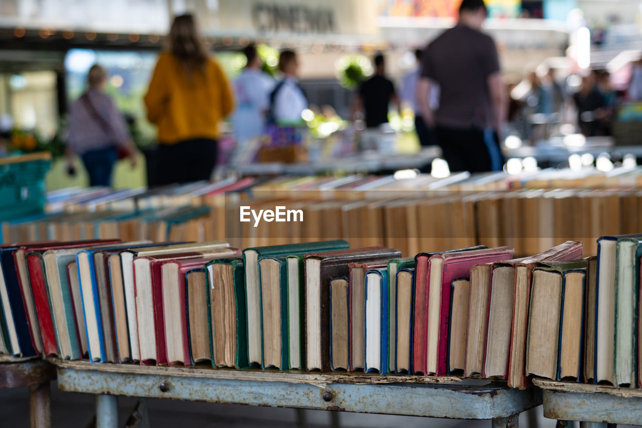 STACK OF BOOKS ON SHELF AT MARKET