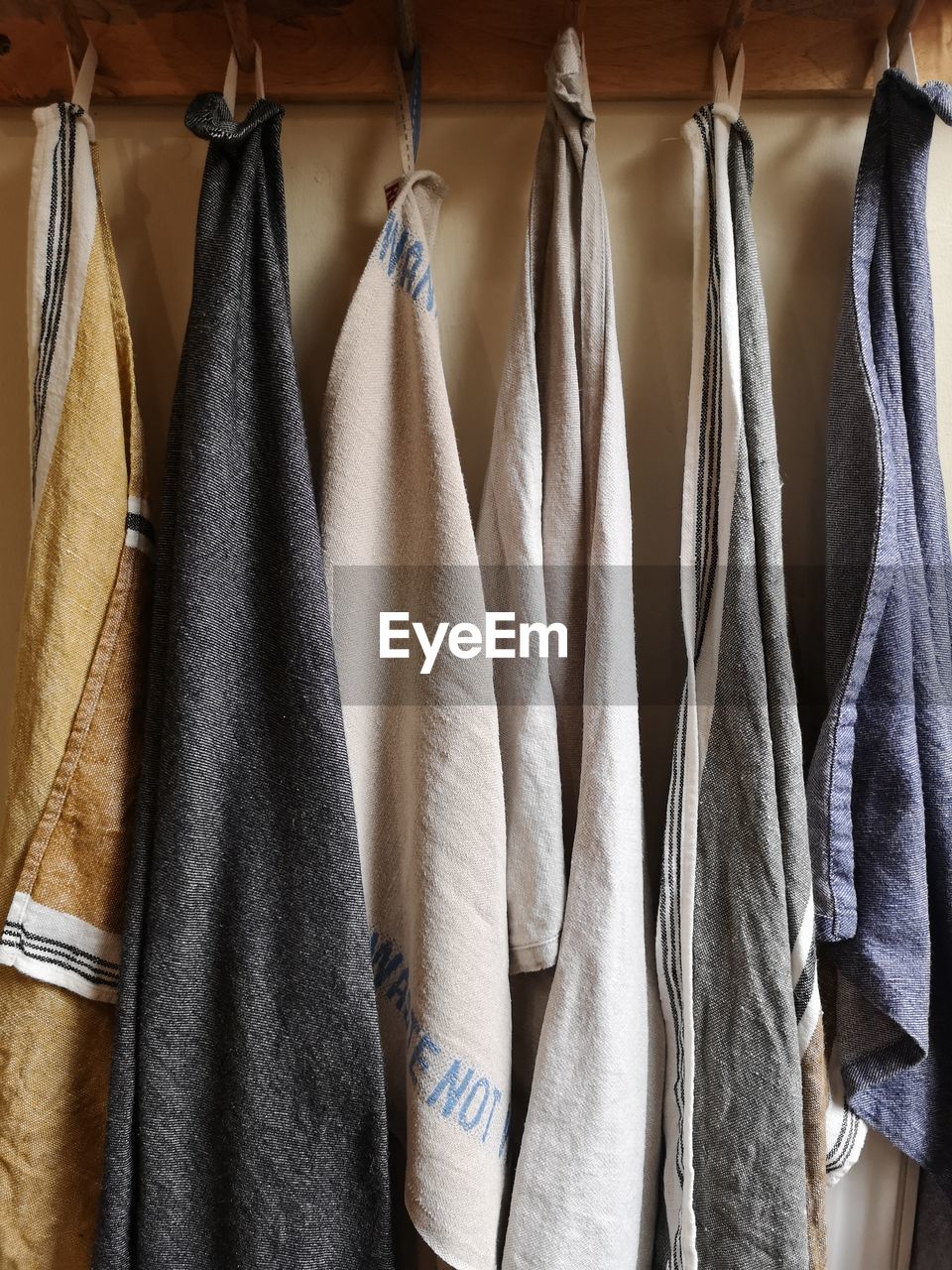 CLOSE-UP OF CLOTHES HANGING ON RACK IN ROW
