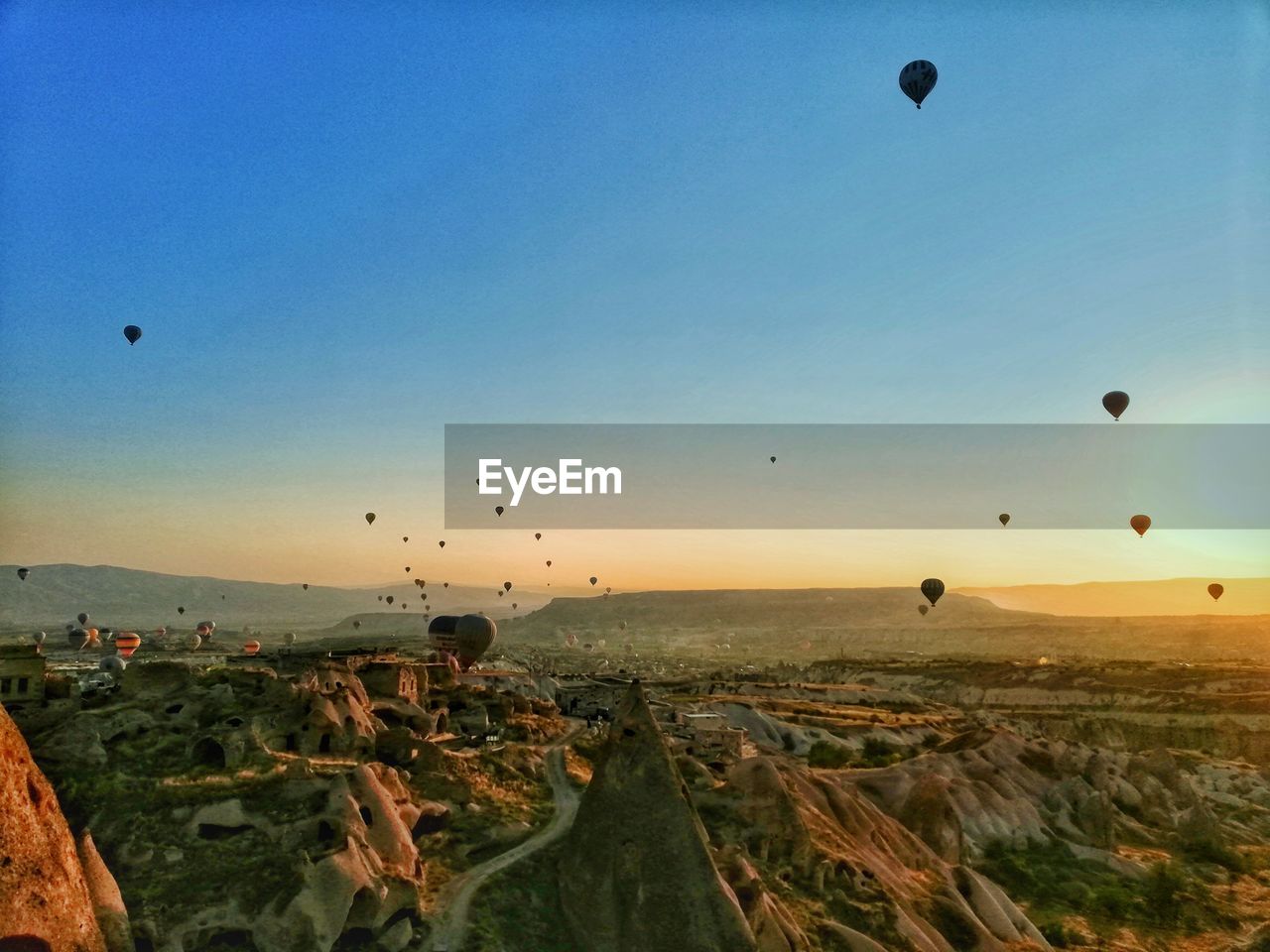 HOT AIR BALLOONS FLYING OVER LANDSCAPE