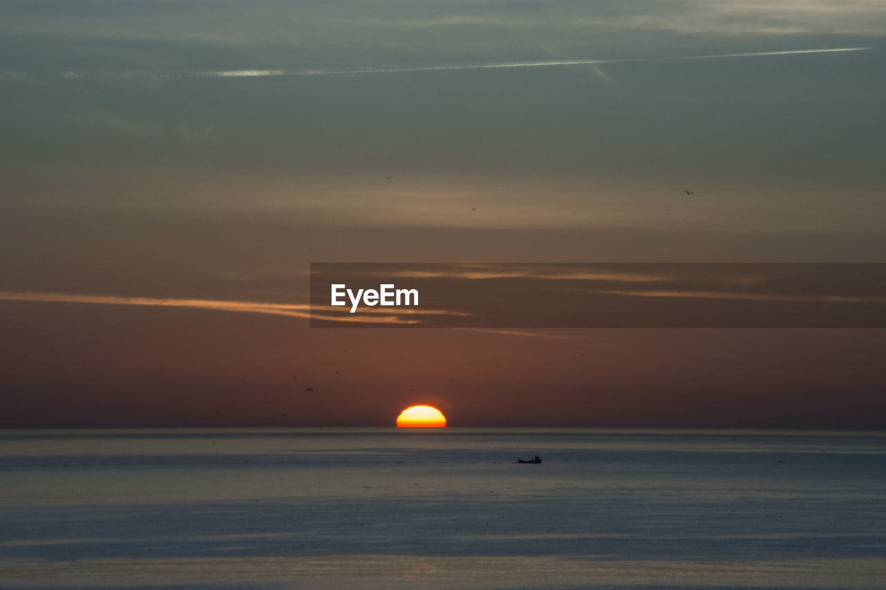 SCENIC VIEW OF SEA AGAINST ORANGE SKY DURING SUNSET