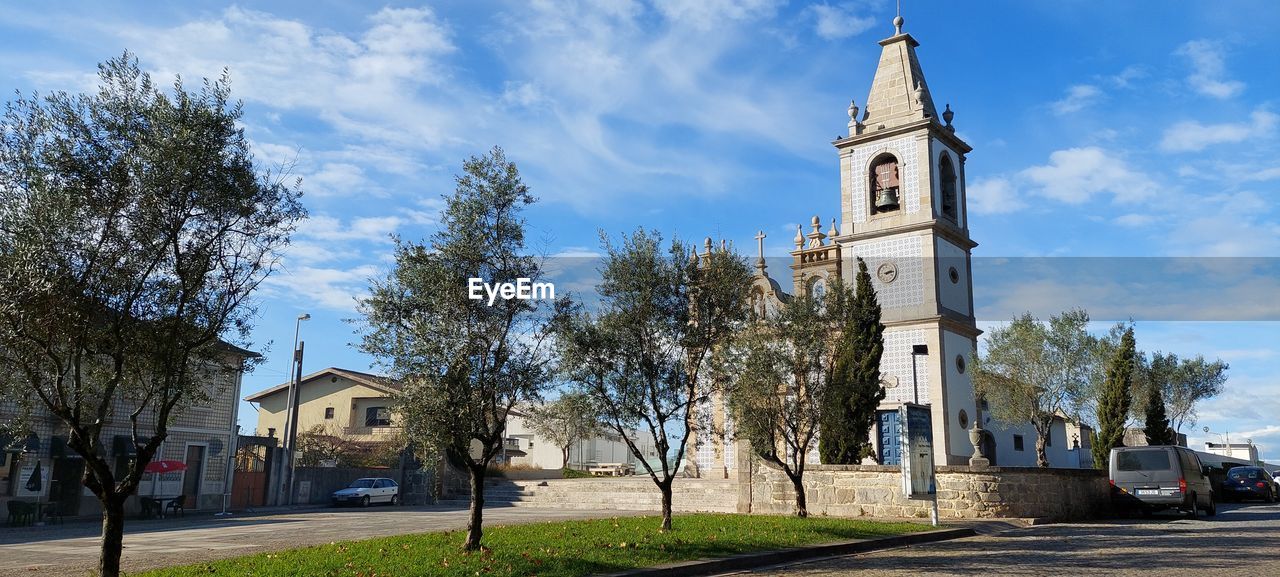 Low angle view of trees and buildings against sky