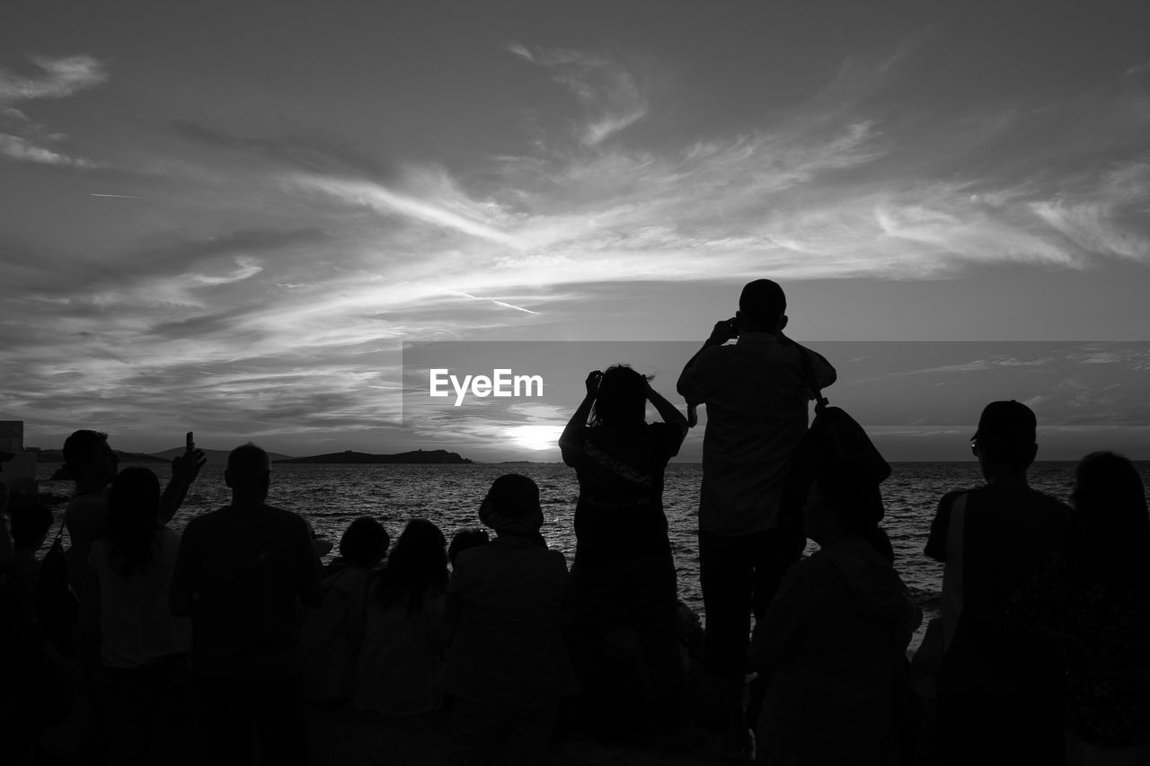 People at beach against sky