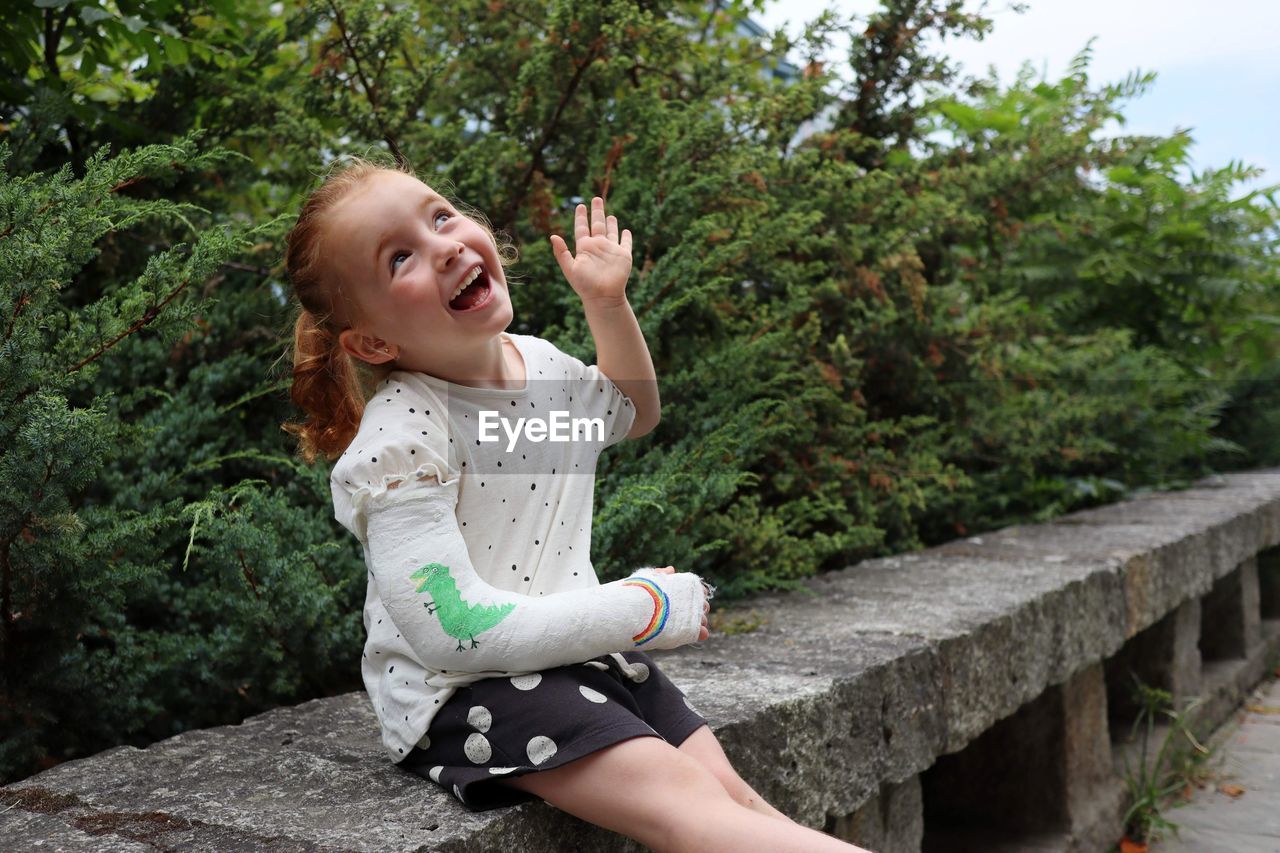 Smiling girl sitting by plants