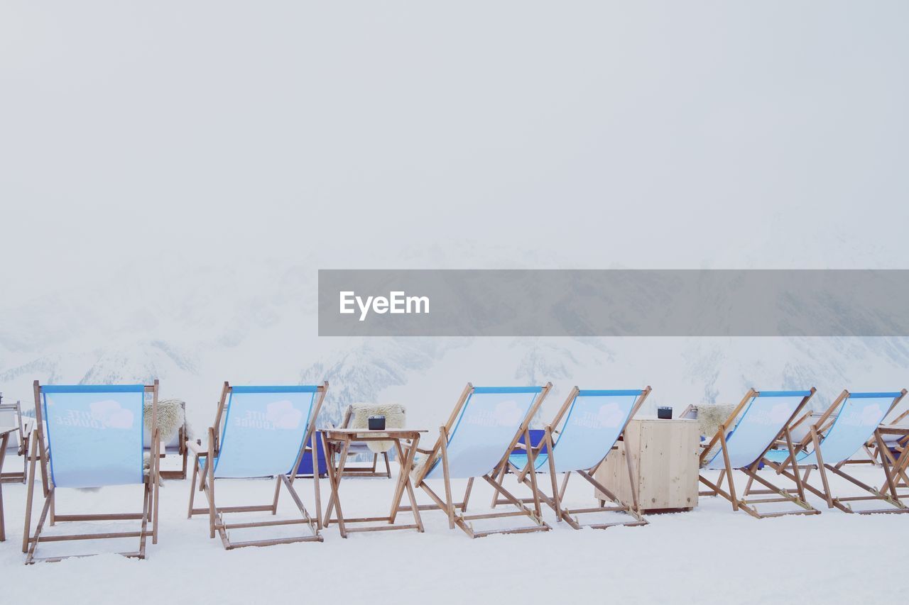 CHAIRS ON BEACH AGAINST CLEAR SKY